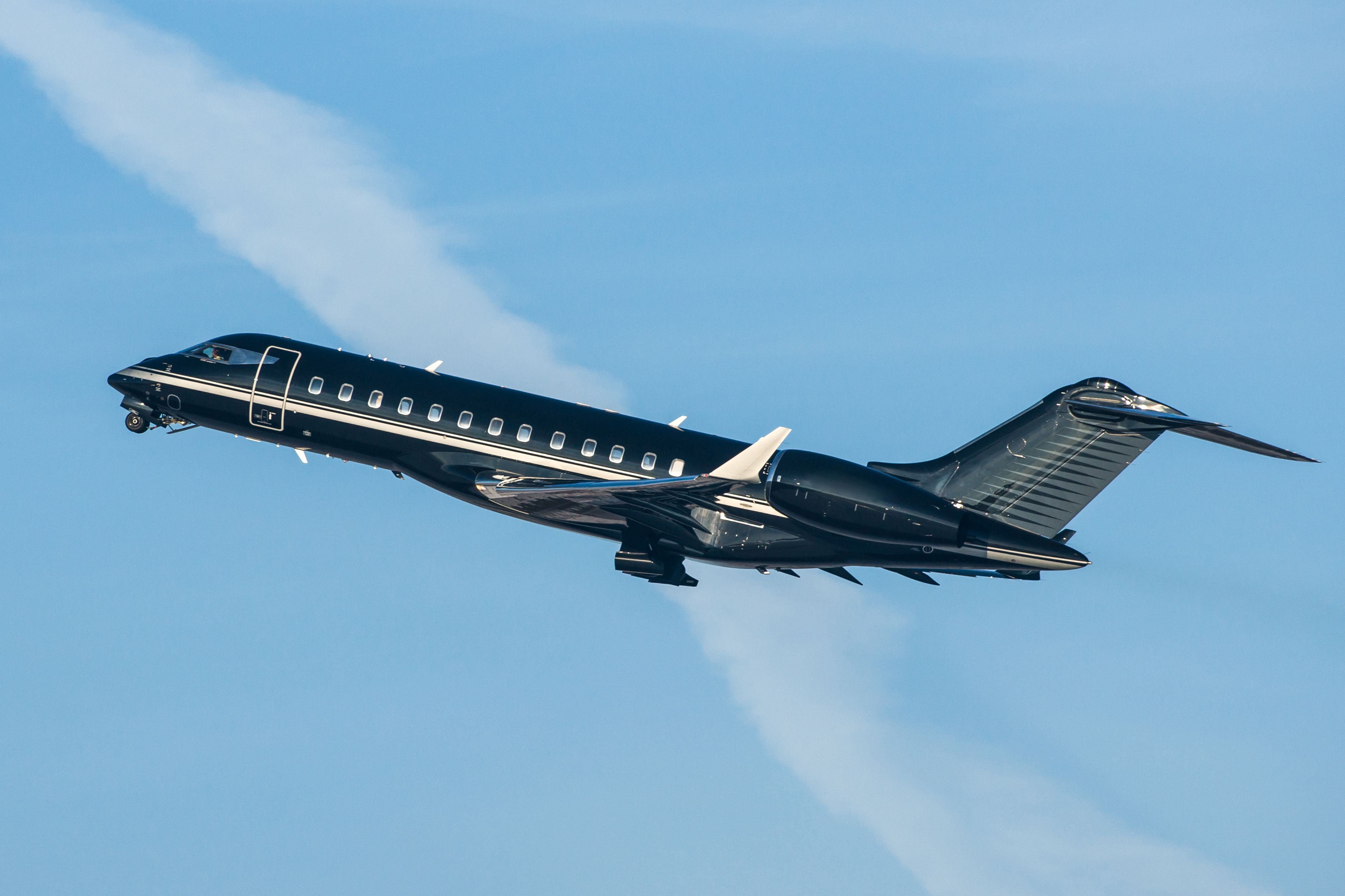 A Black Business Jet Flying In The Sky.