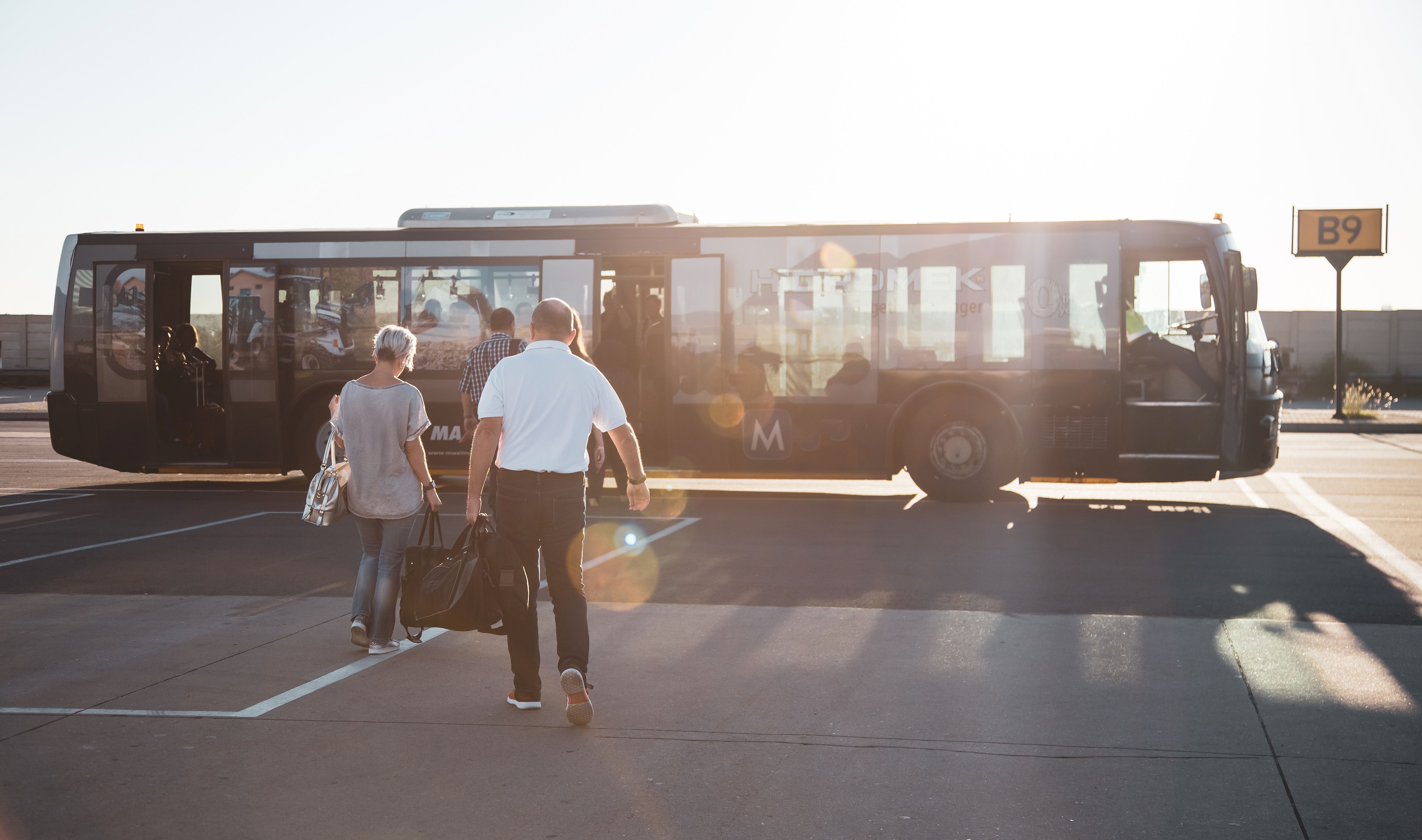 shutterstock_1330916207 - stock photo of airport bus with pilot and passenger boarding
