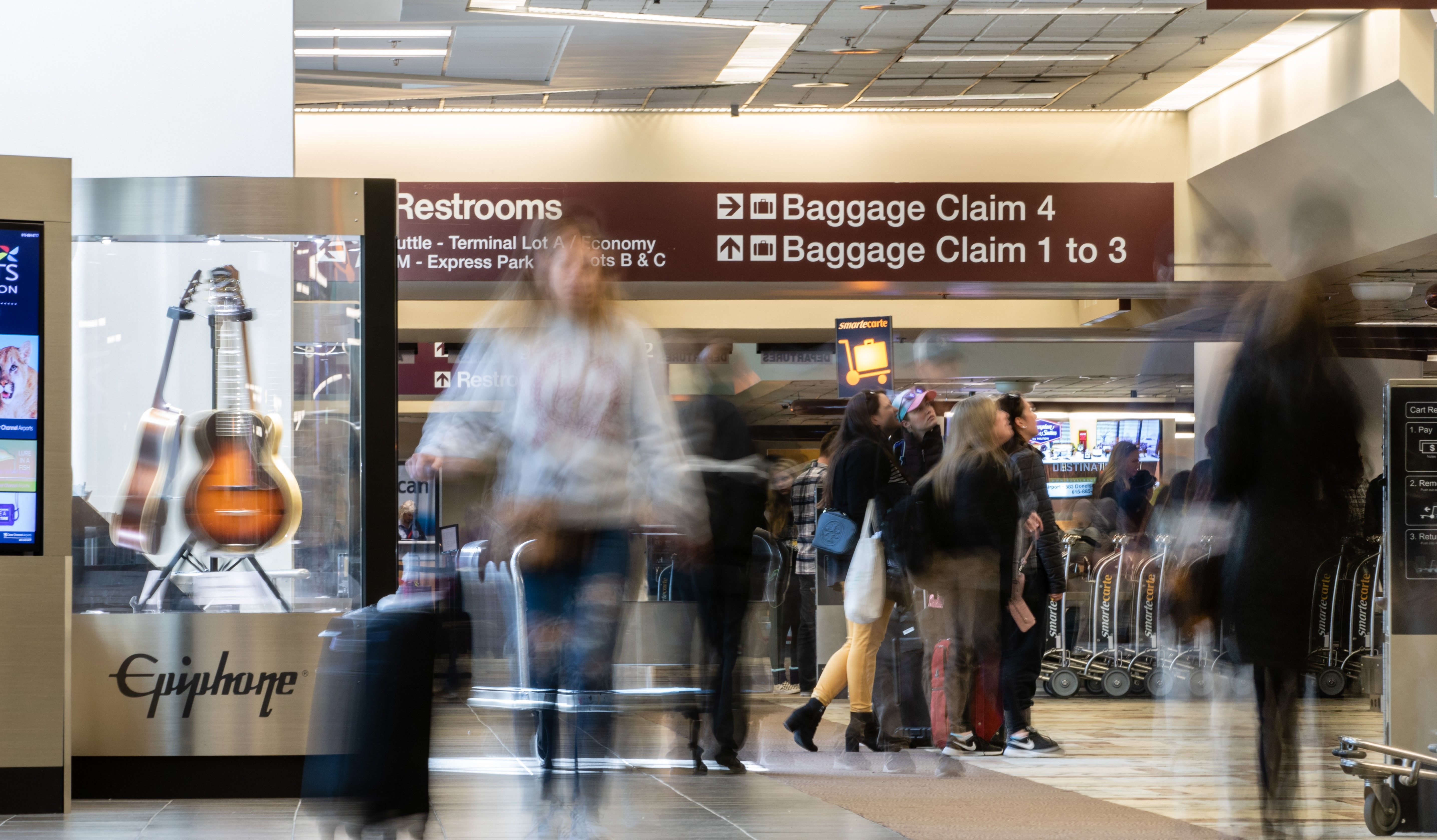 People in motion in the baggage claim area at Nashville International Airport (BNA).
