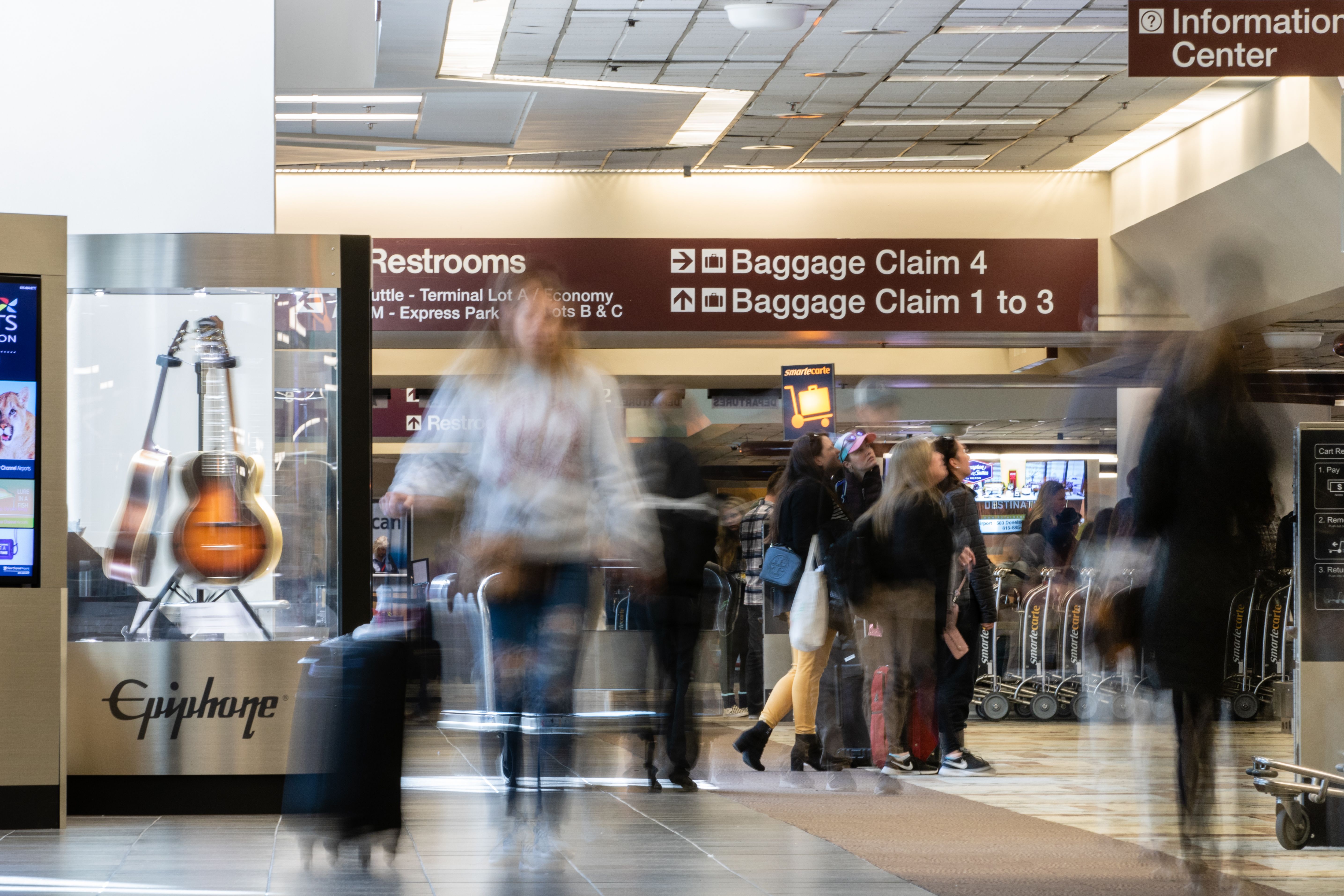 People in motion in the baggage claim area at Nashville International Airport (BNA).