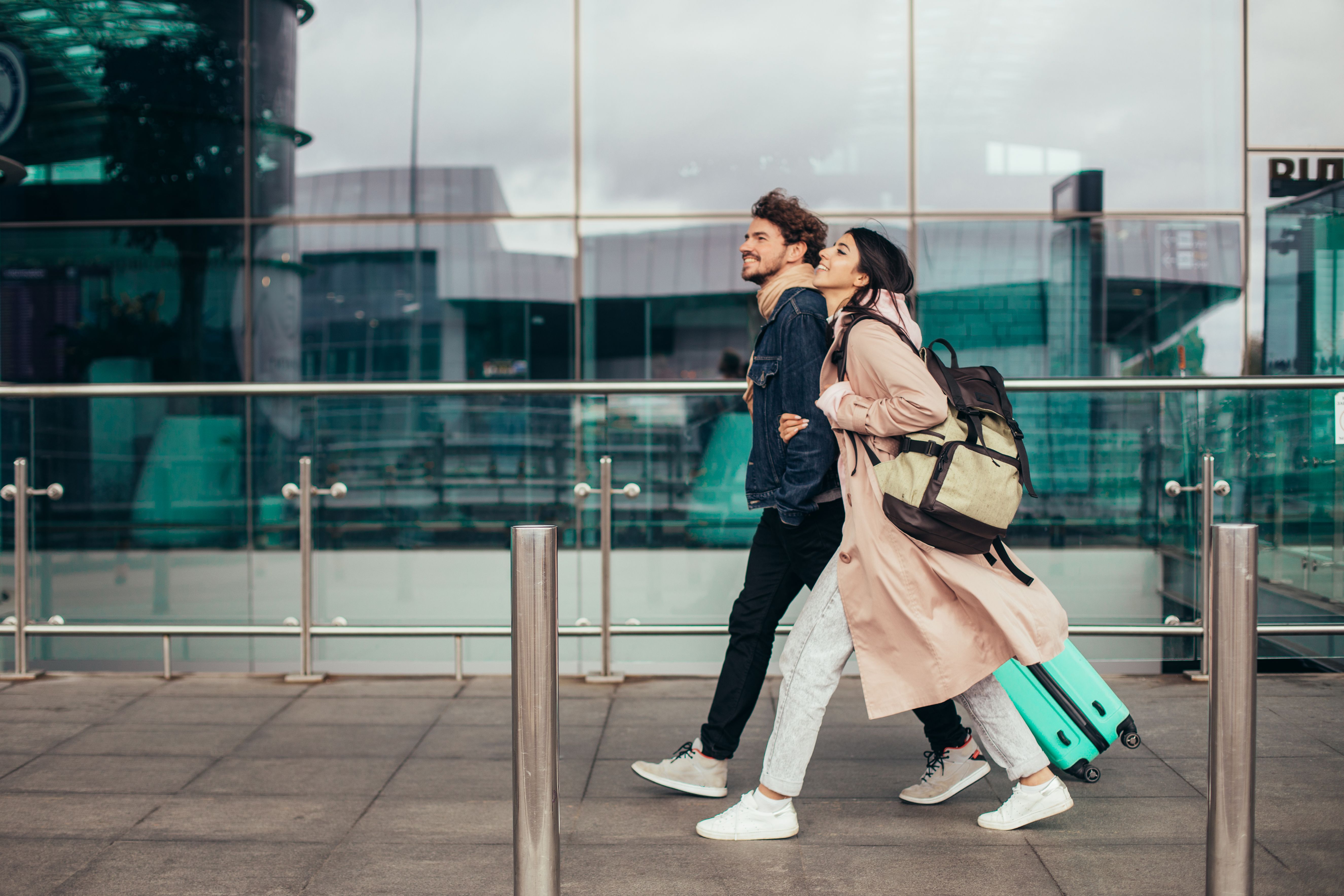 A Couple walking together at the airport .