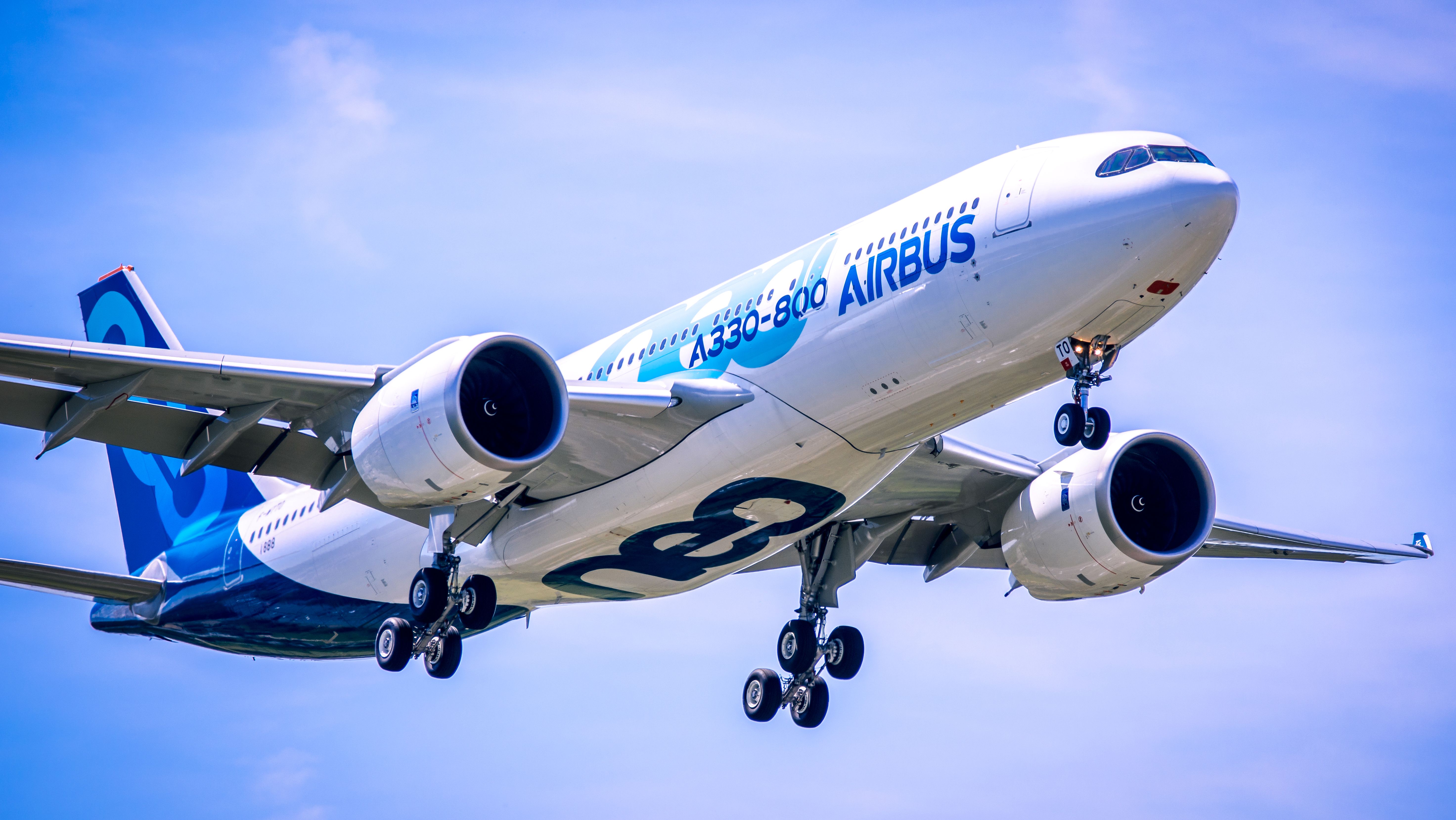 An Airbus A330neo in house livery flying in the sky.