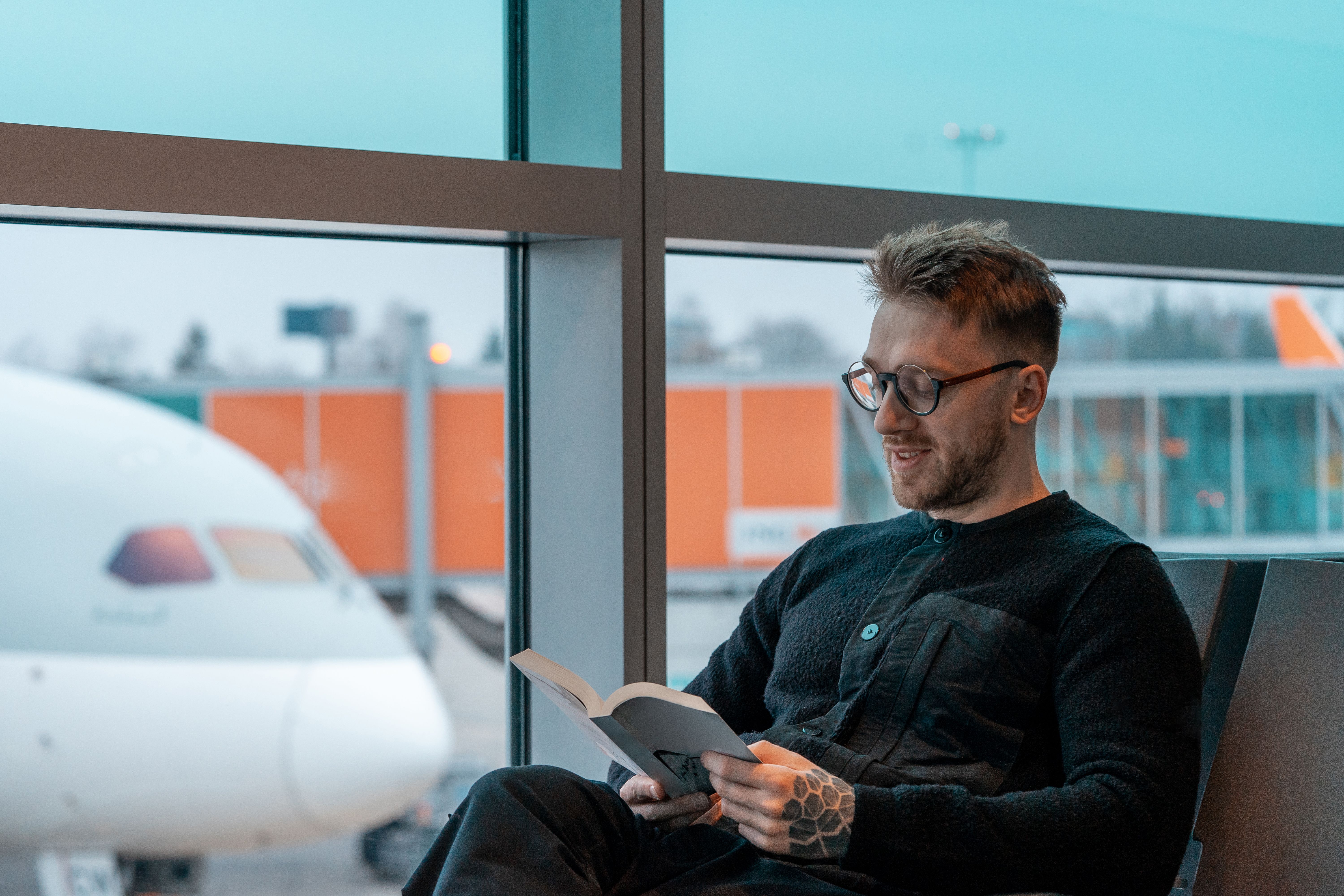 Person reading a book at the airport