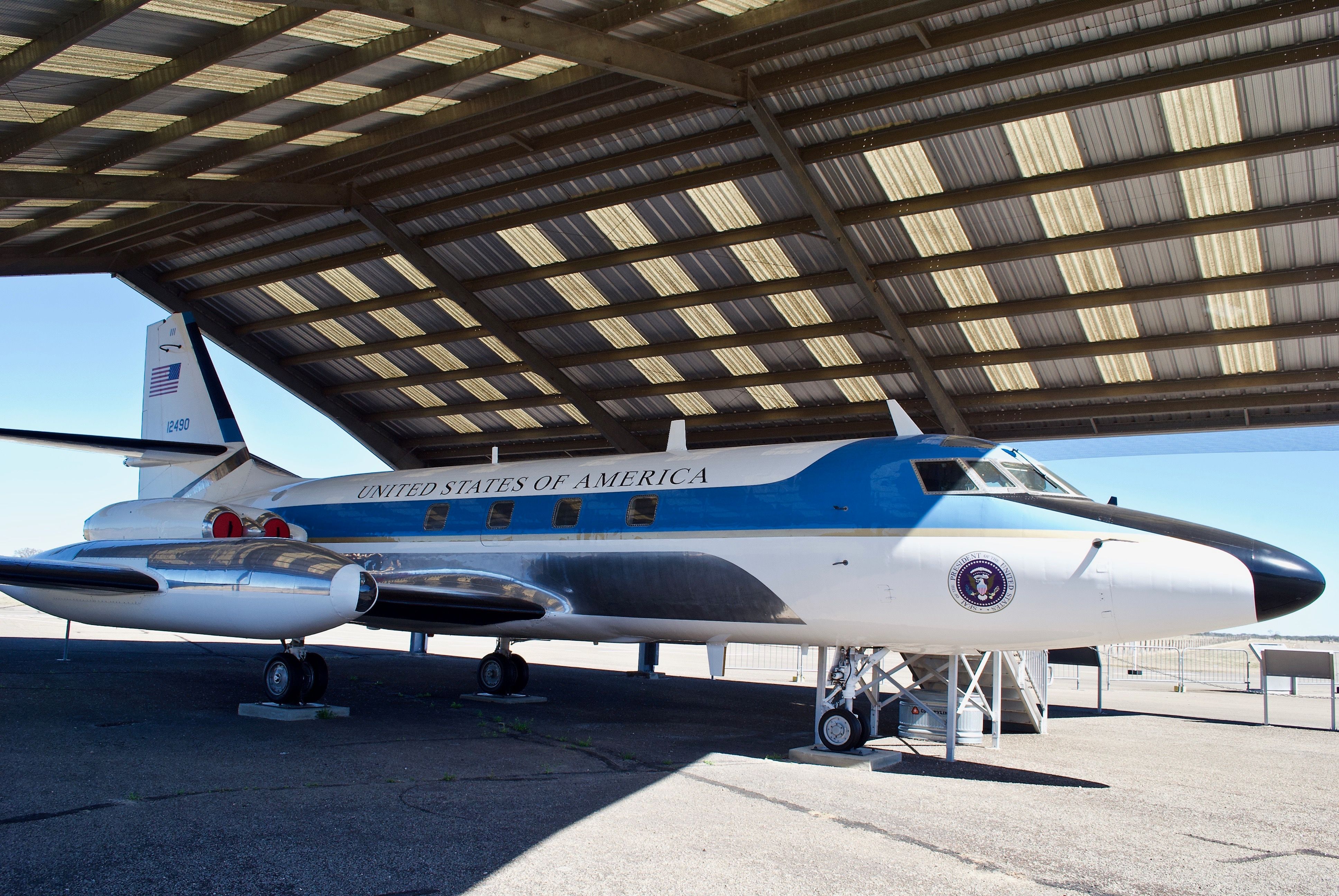 A US Government Lockheed Jetstar parked near an airfield.