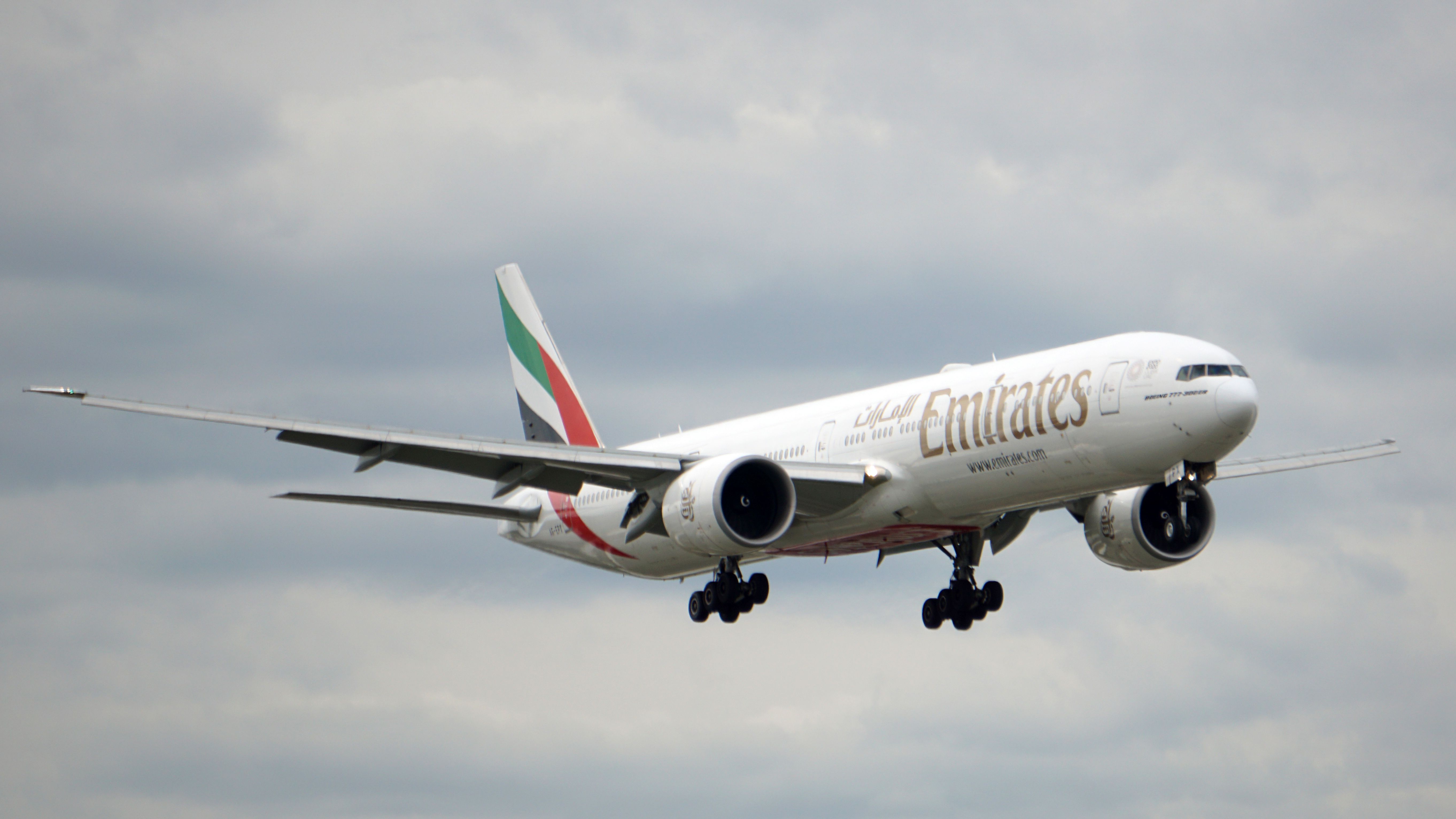 An Emirates Boeing 777-300ER flying in the sky.