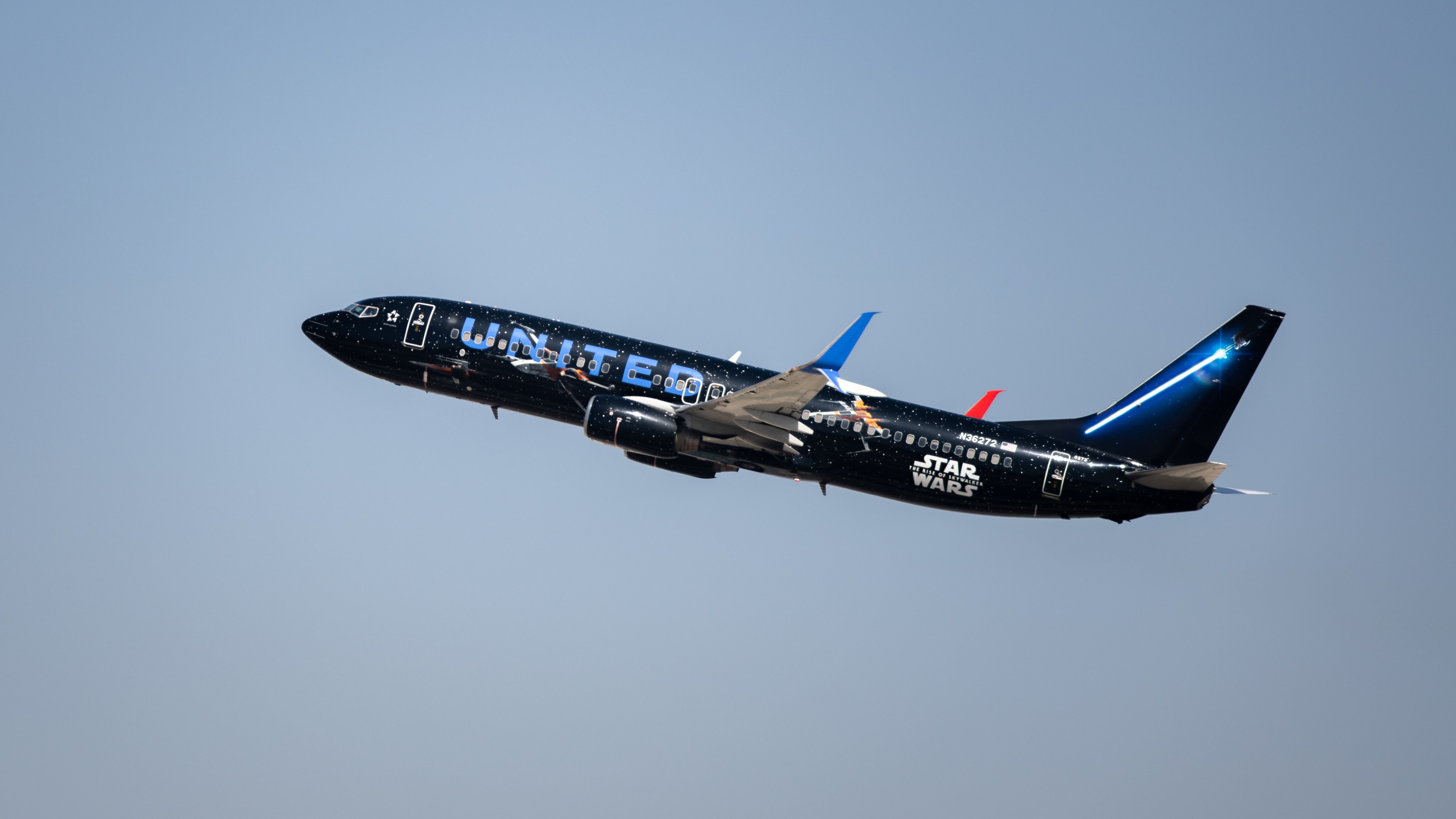 A United Airlines plane in Star Wars Livery flying in the sky.
