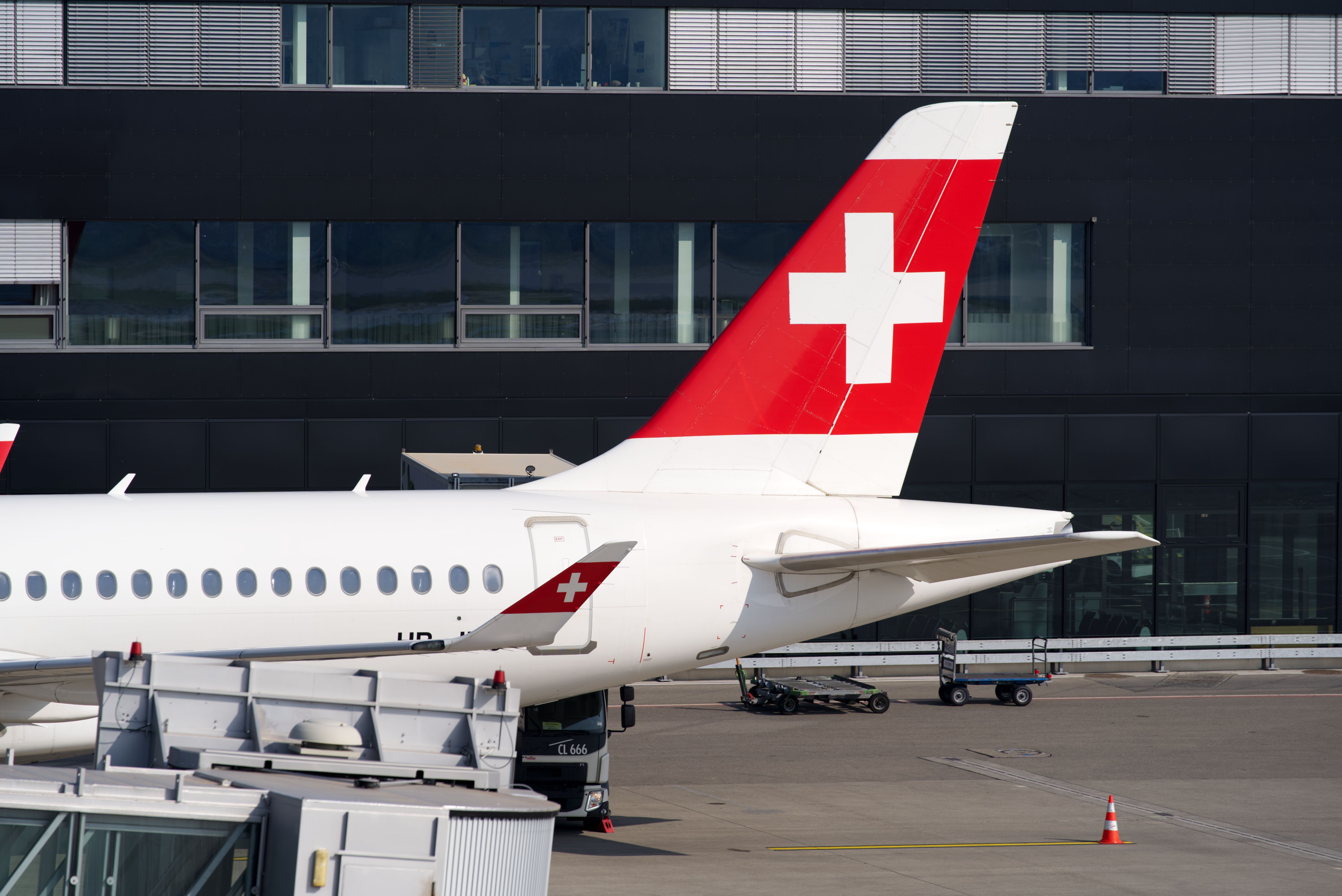 A Swiss Airbus A220 jet parked at an airport