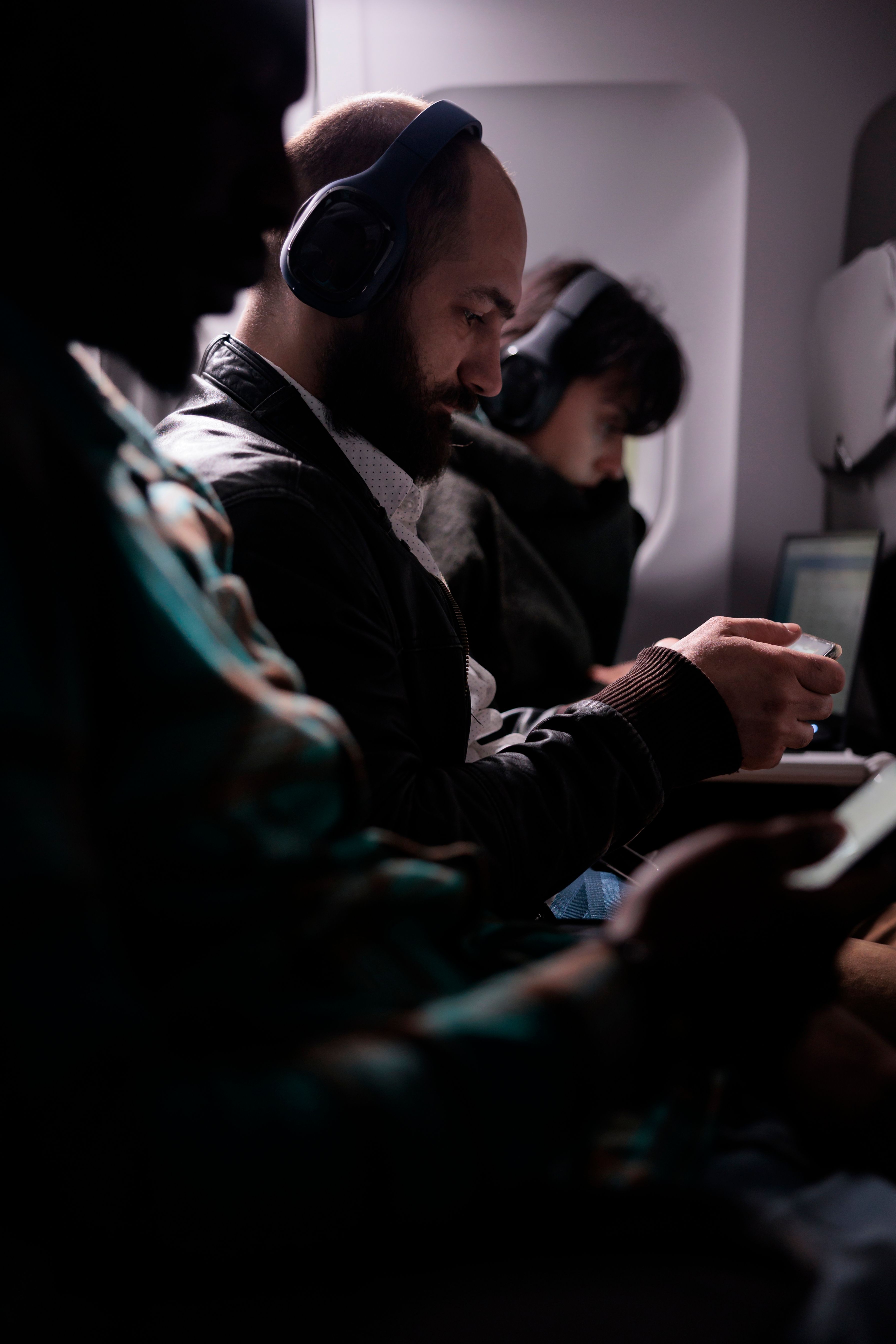 Three Passengers sitting in an economy class cabin.