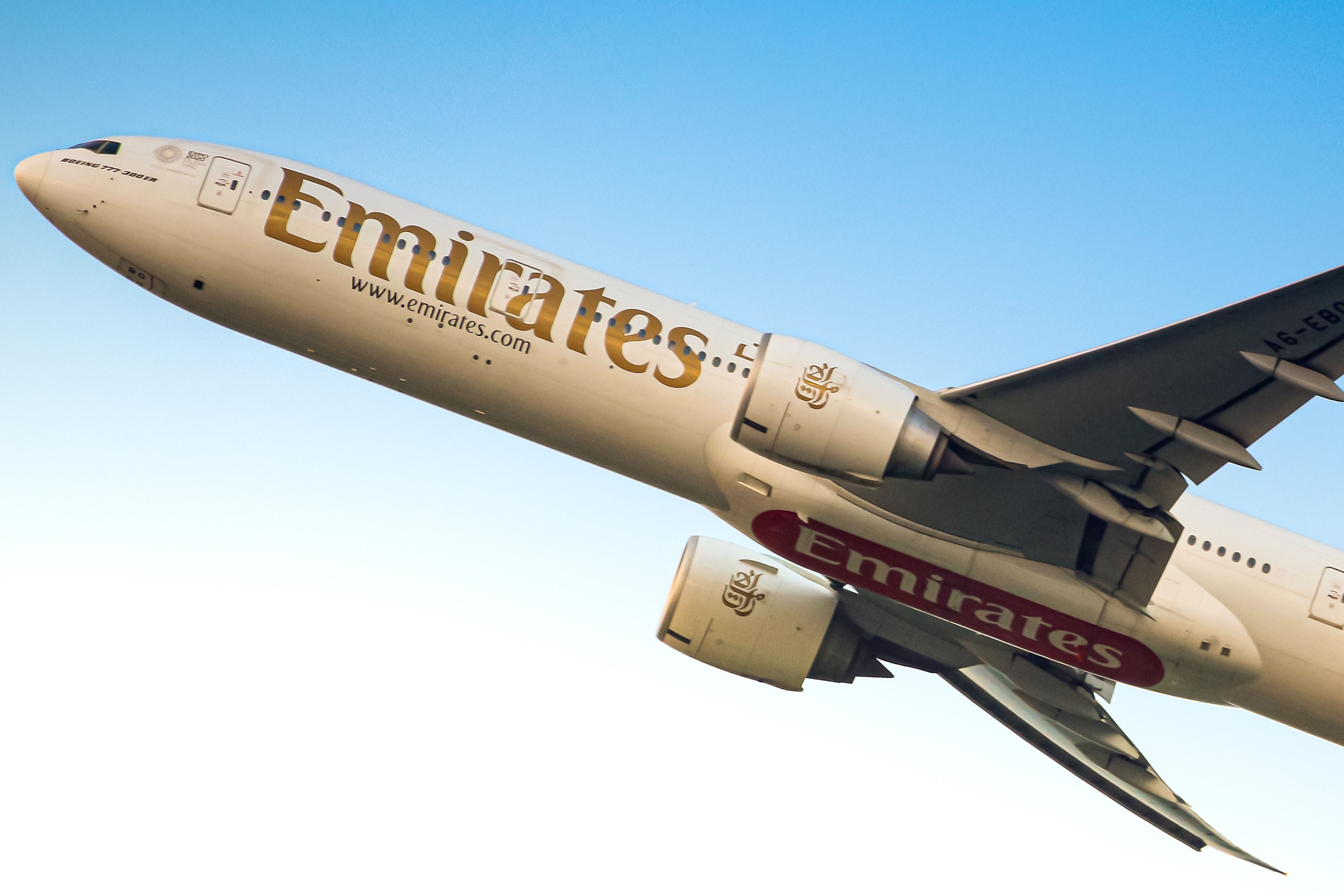 An Emirates Boeing 777-300ER flying in the sky.