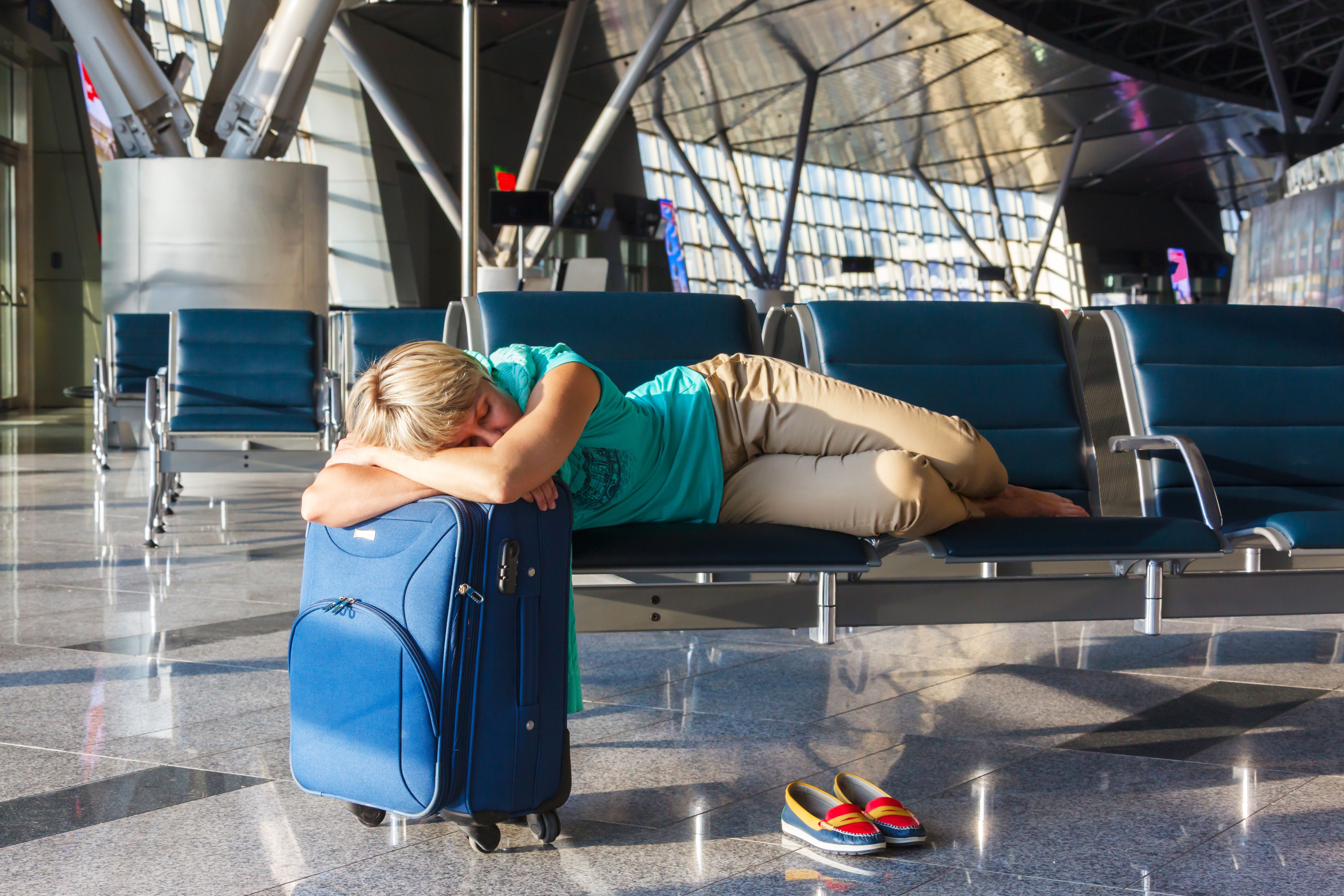 A passenger sleeping in an airport.