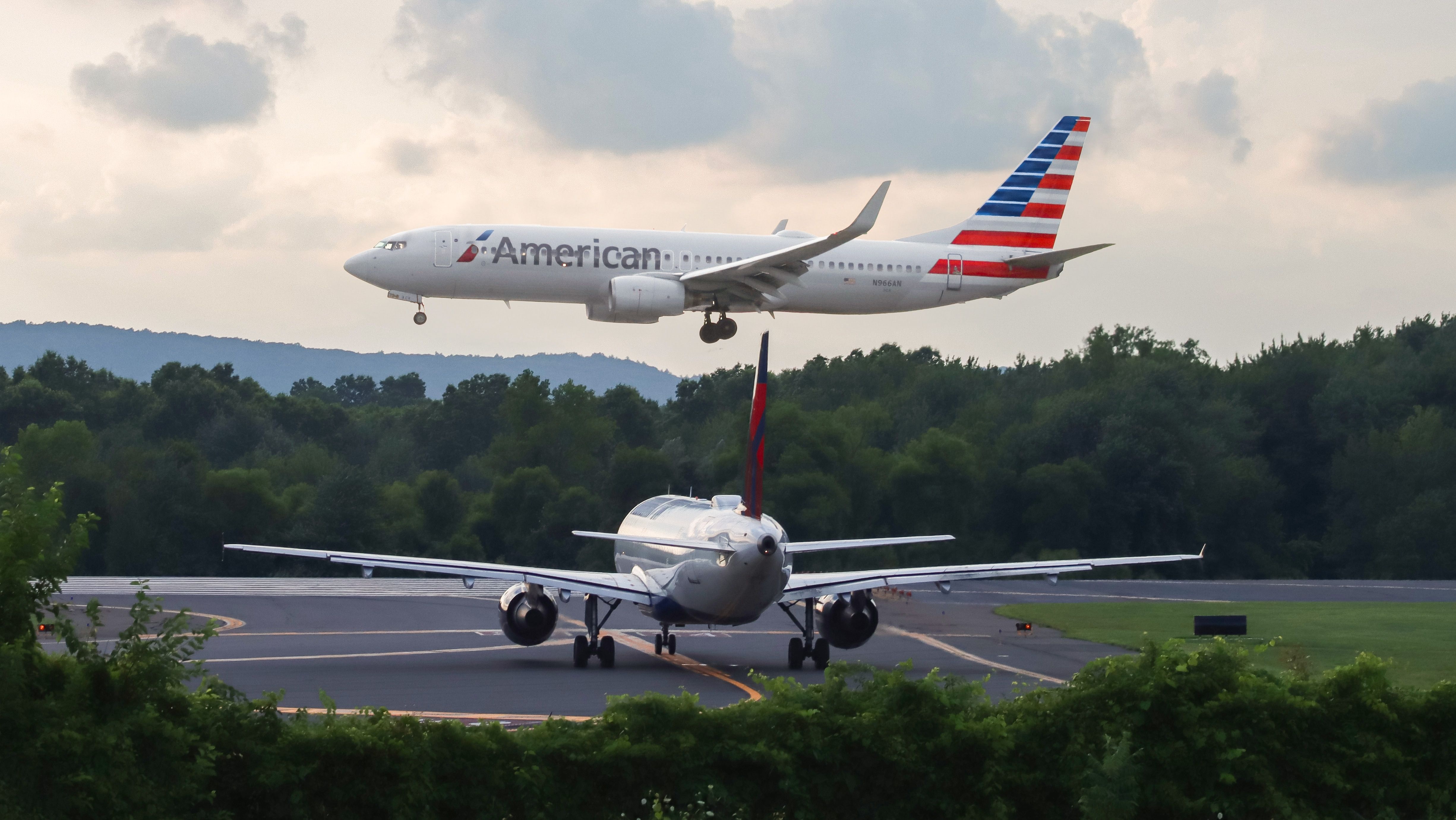 An American Boeing 737 Flying Past A Delta Air Lines Airbus A320.