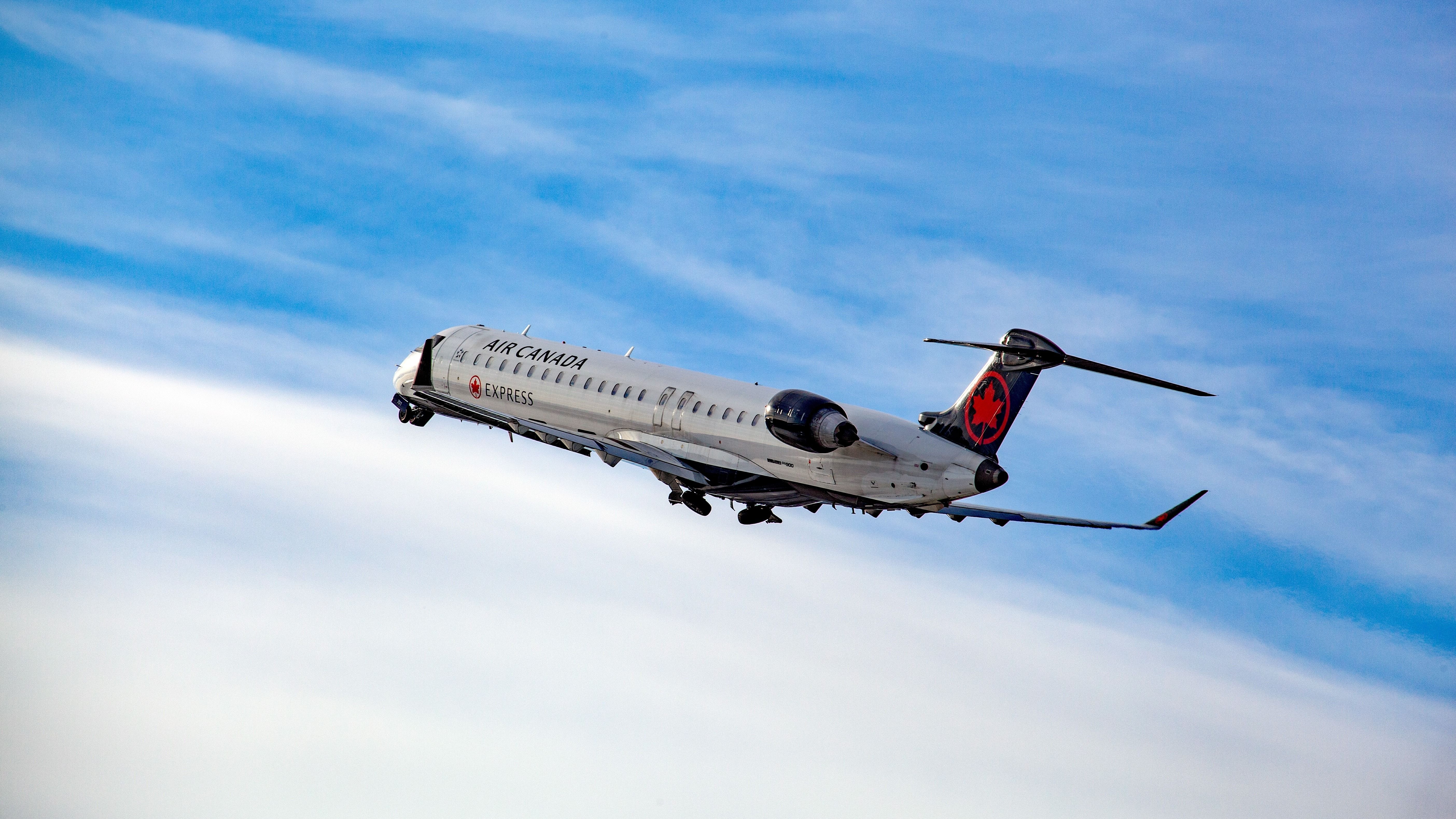 Air Canada Express Bombardier CRJ-900 ascending in the air after taking off from Montreal International Airport.