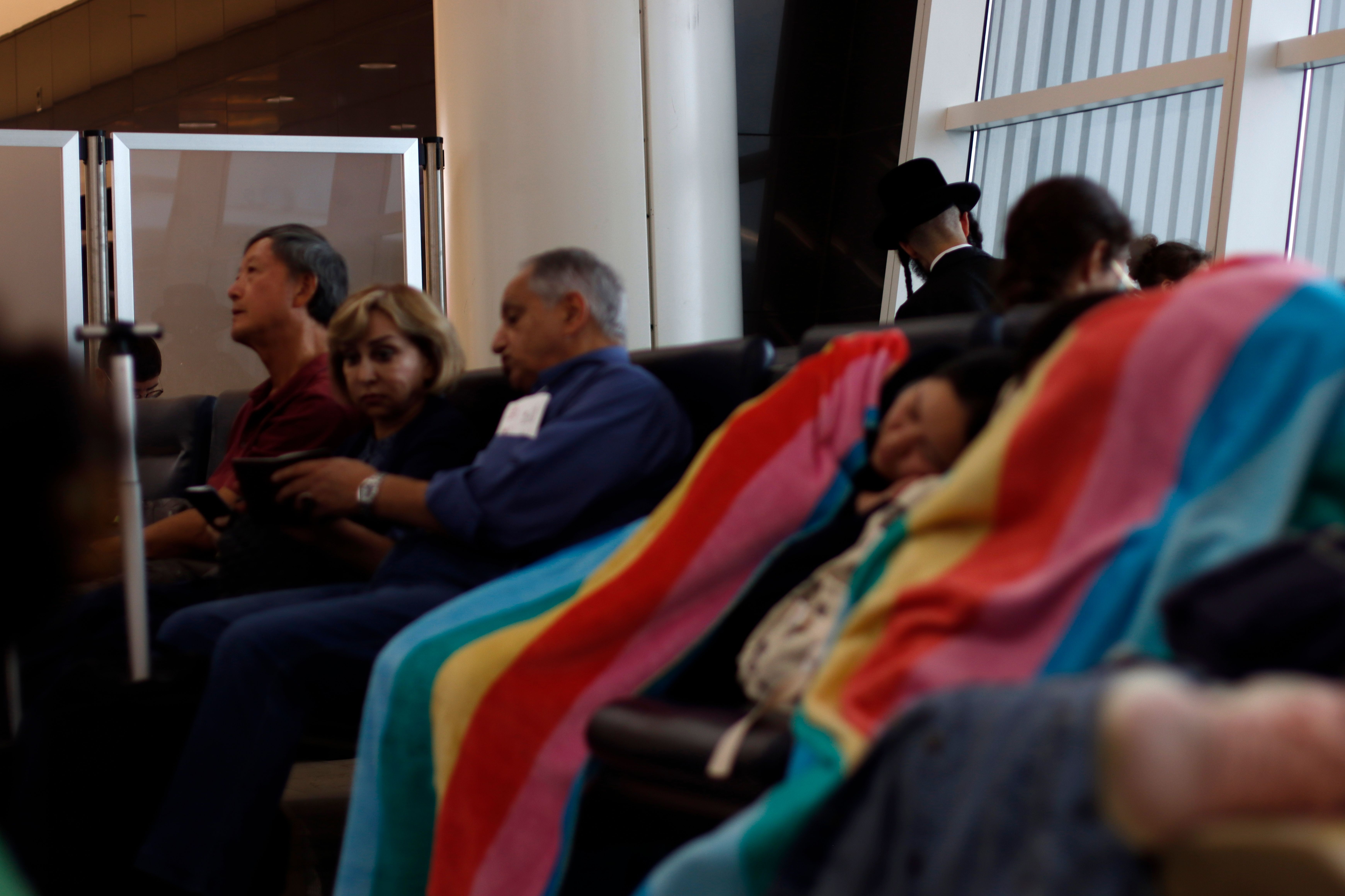 Passengers sleeping in an airport terminal.