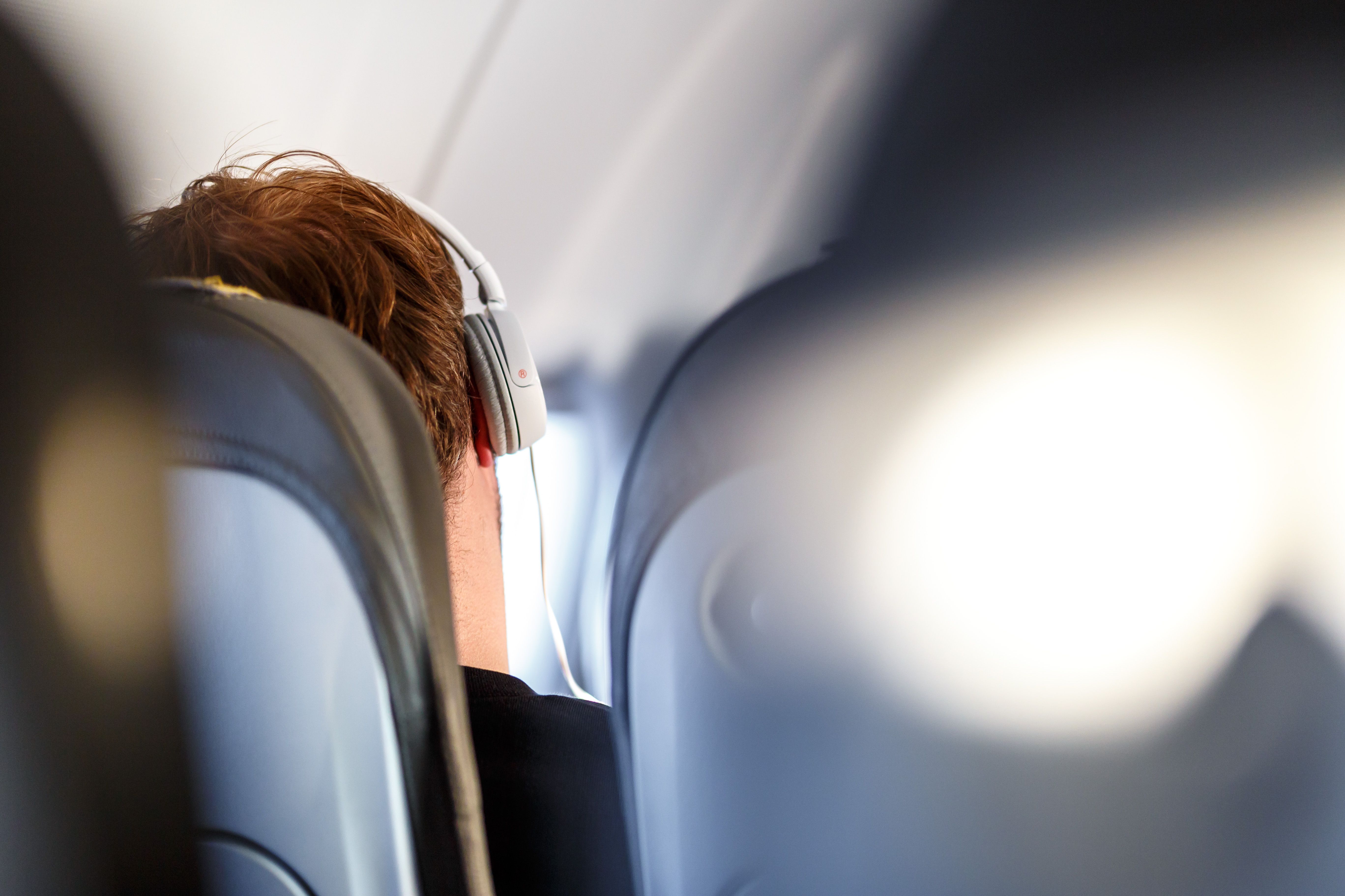 A person listening to music on a plane.