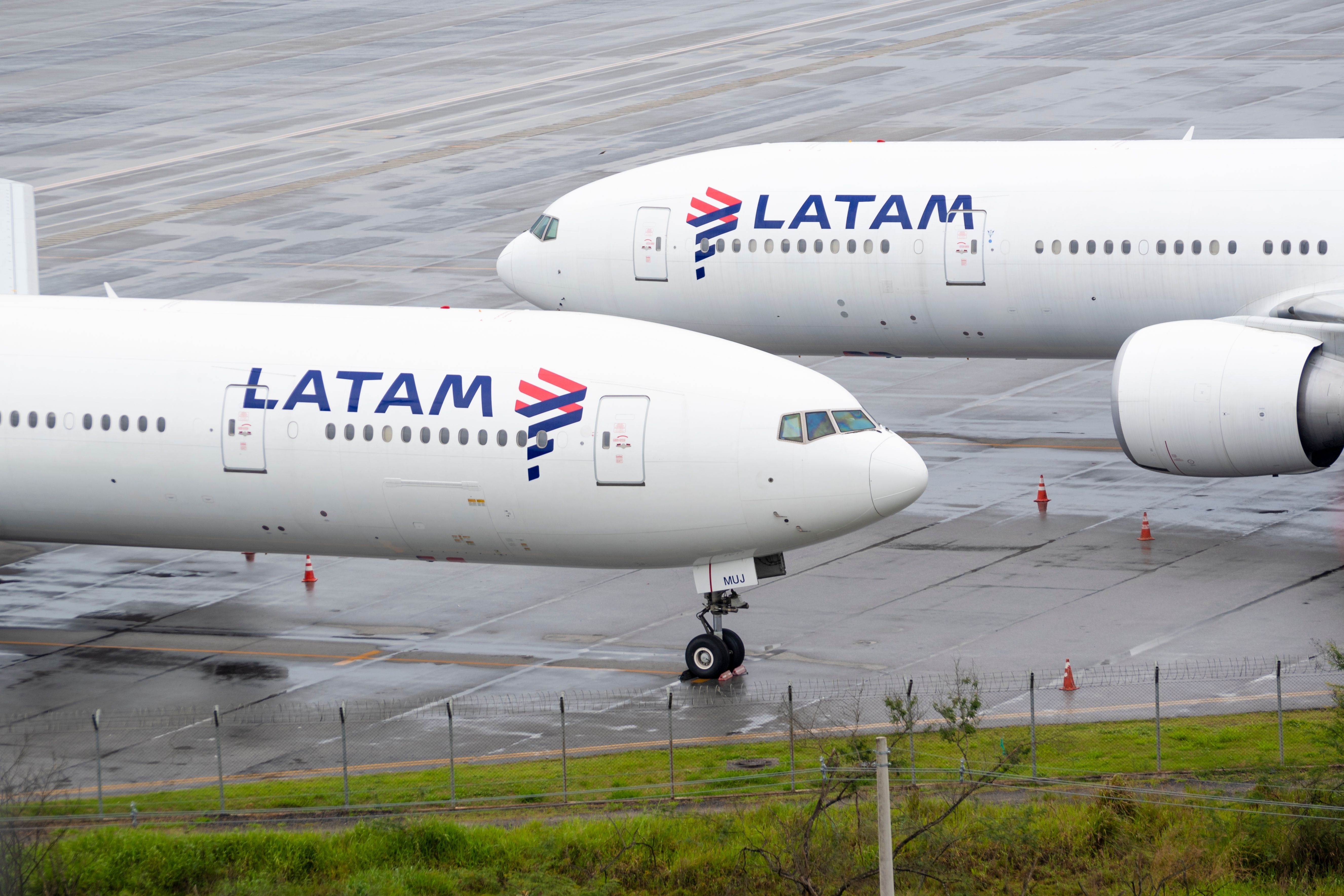 Two LATAM Boeing 777-300s parked at an airport.