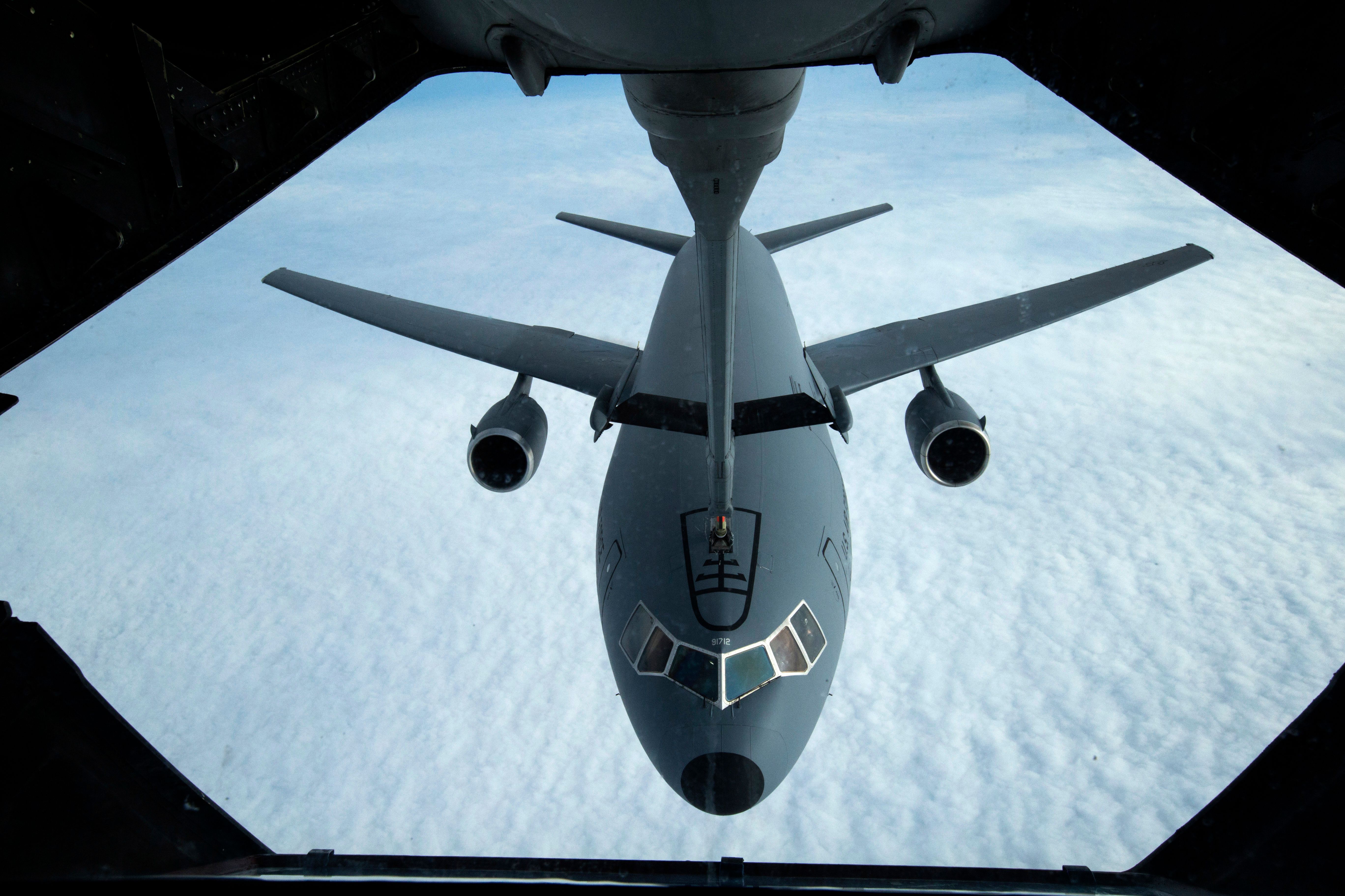 A KC-10 Extender refueling another aircraft above the clouds.