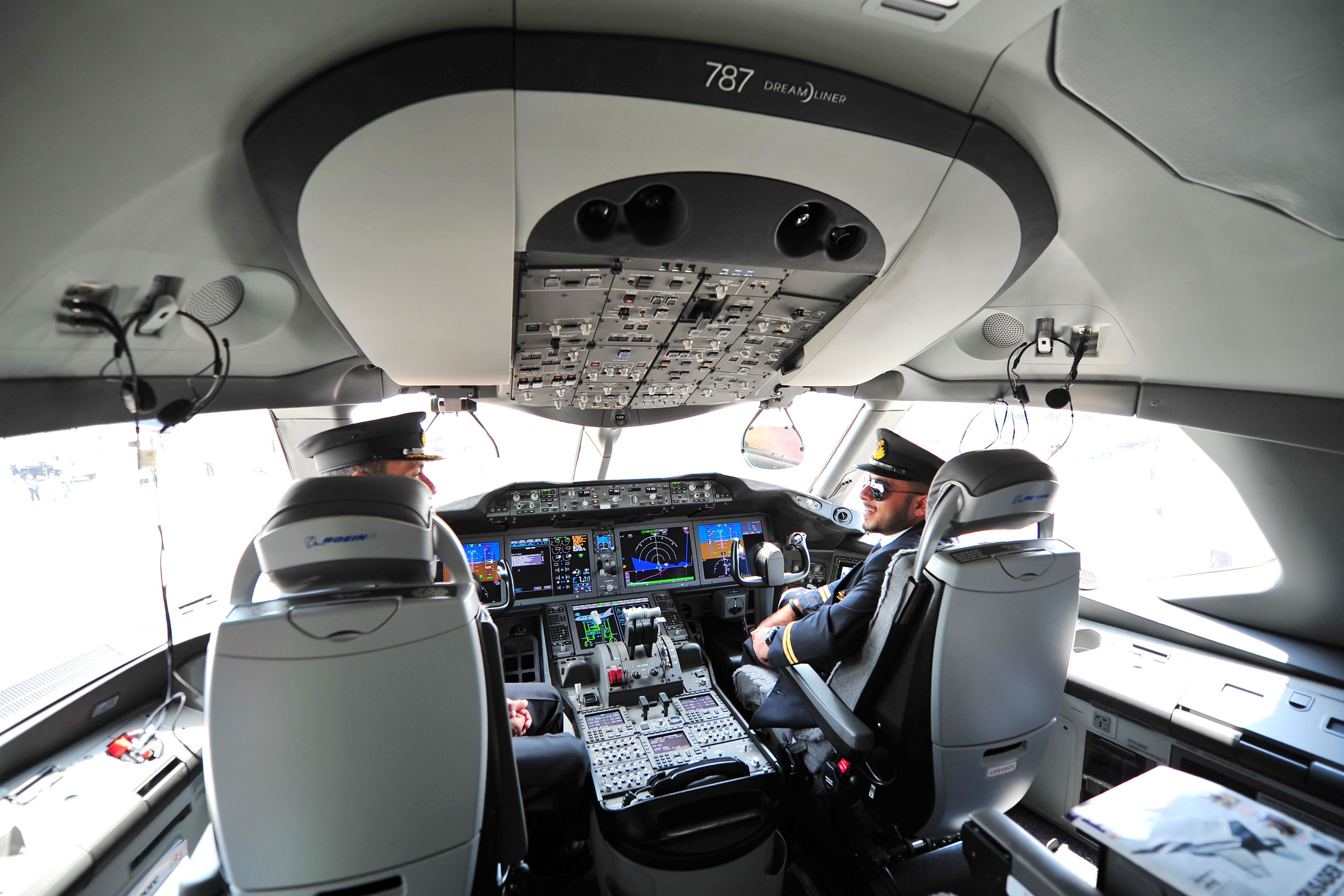 Two pilots sitting in the cockpit of a Boeing 787.