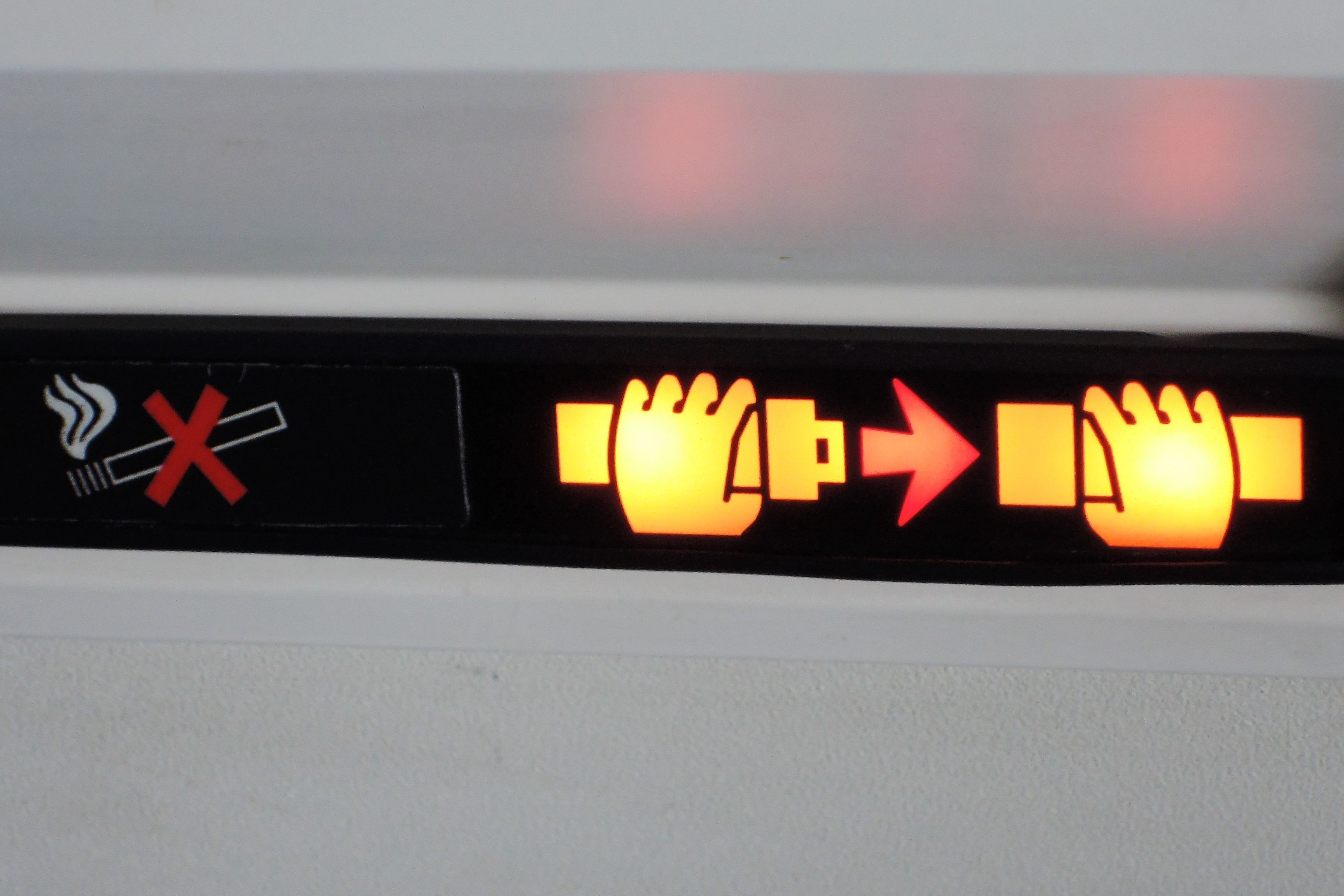 An illuminated seatbelt sign in an aircraft.