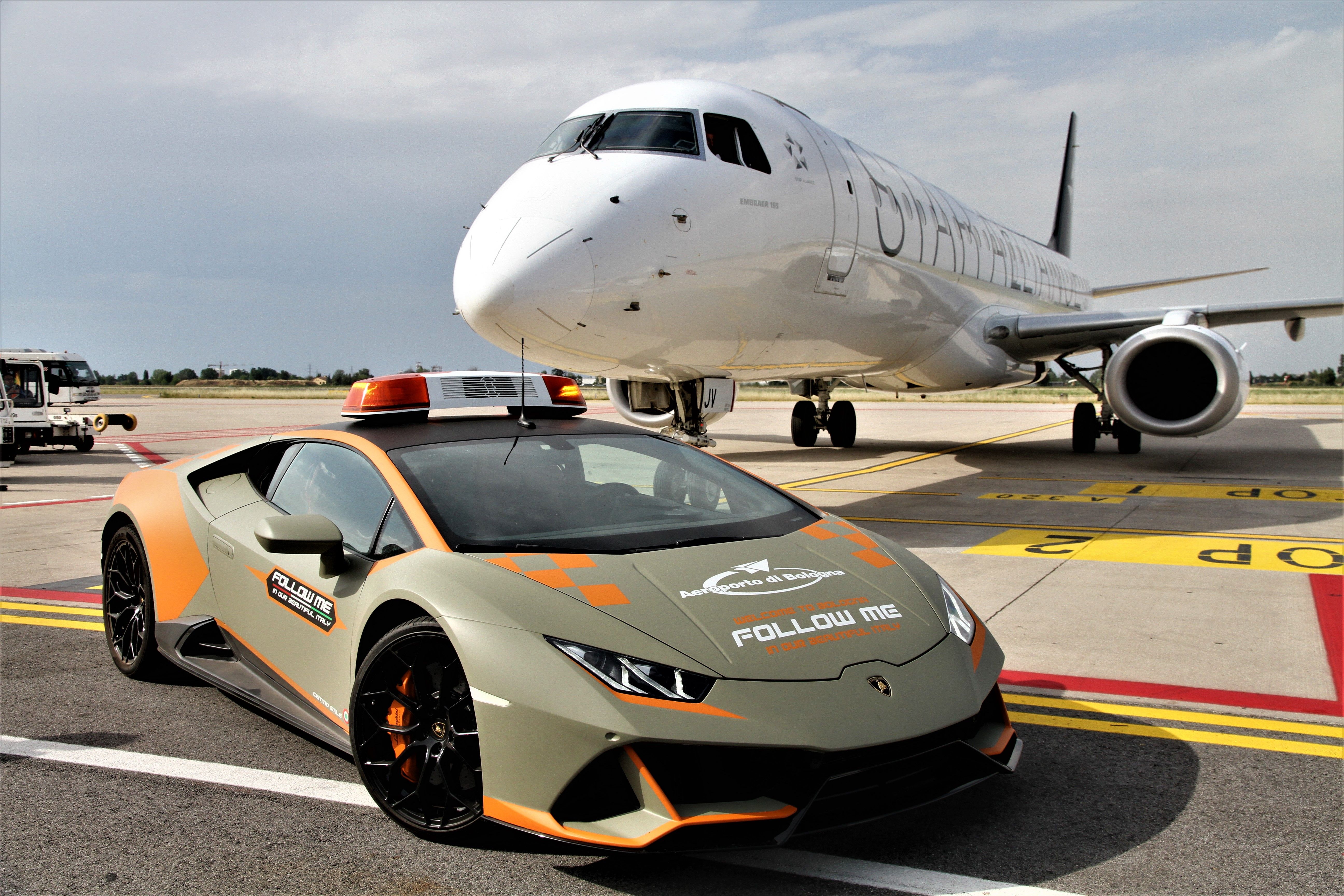 A Lamborghini Huracán Evo Follow Me Car parked in front of a Star Alliance-liveried aircraft.