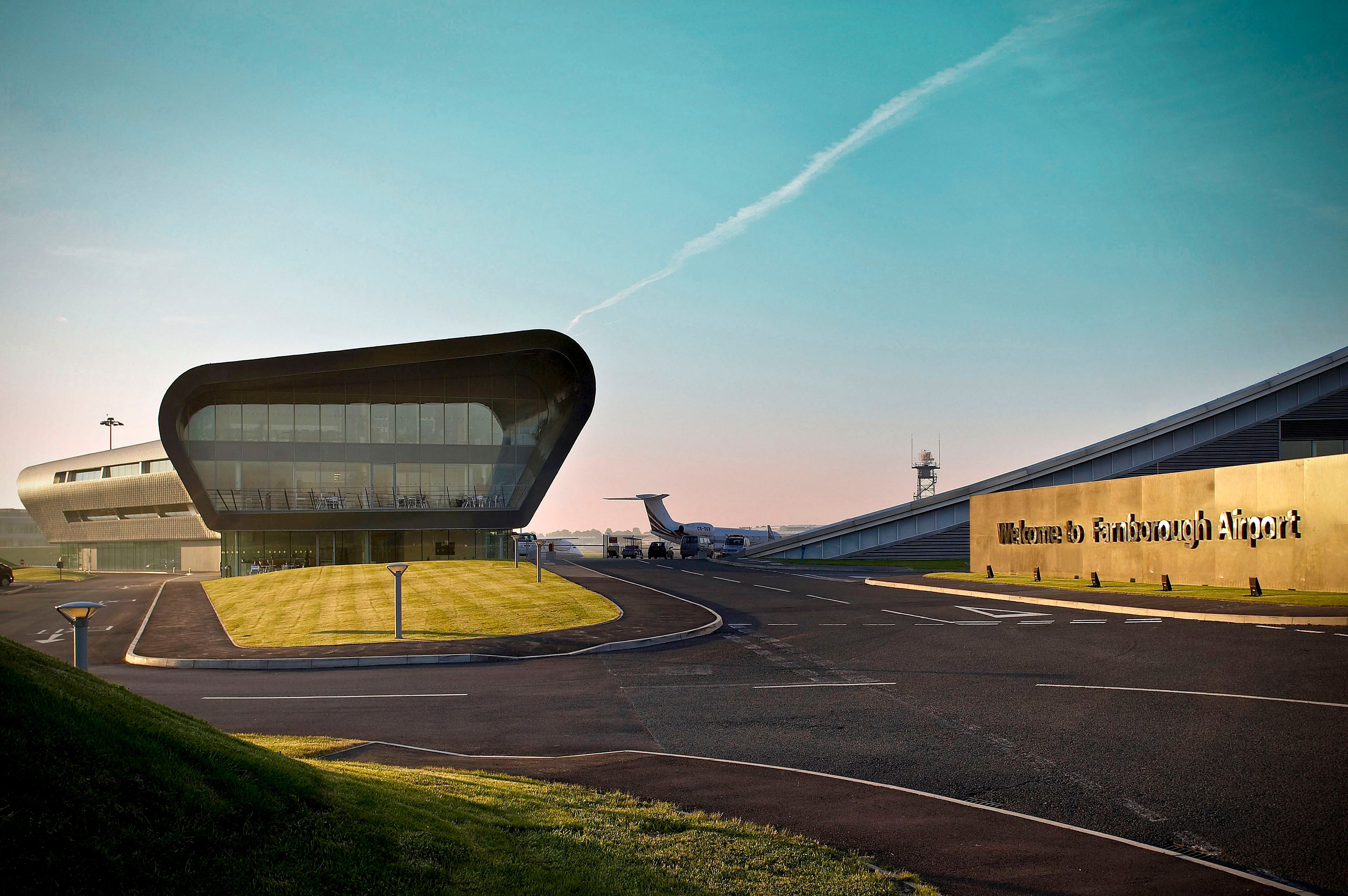 The main building and welcome sign for Farnborough Airport.