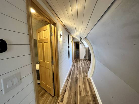 a hallway with a door and a wood floor