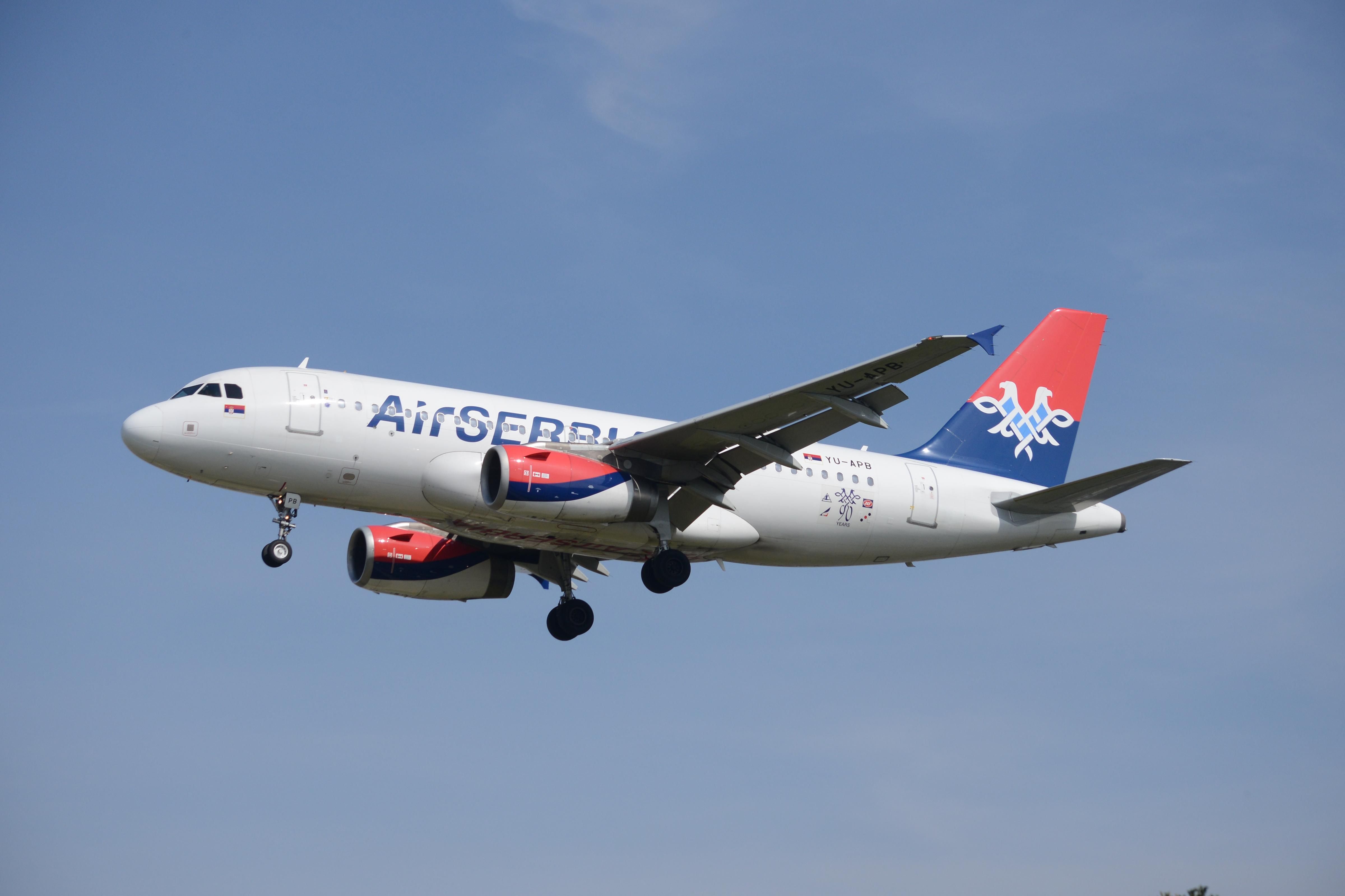 An Air Serbia Airbus A319-100 flying in the sky.