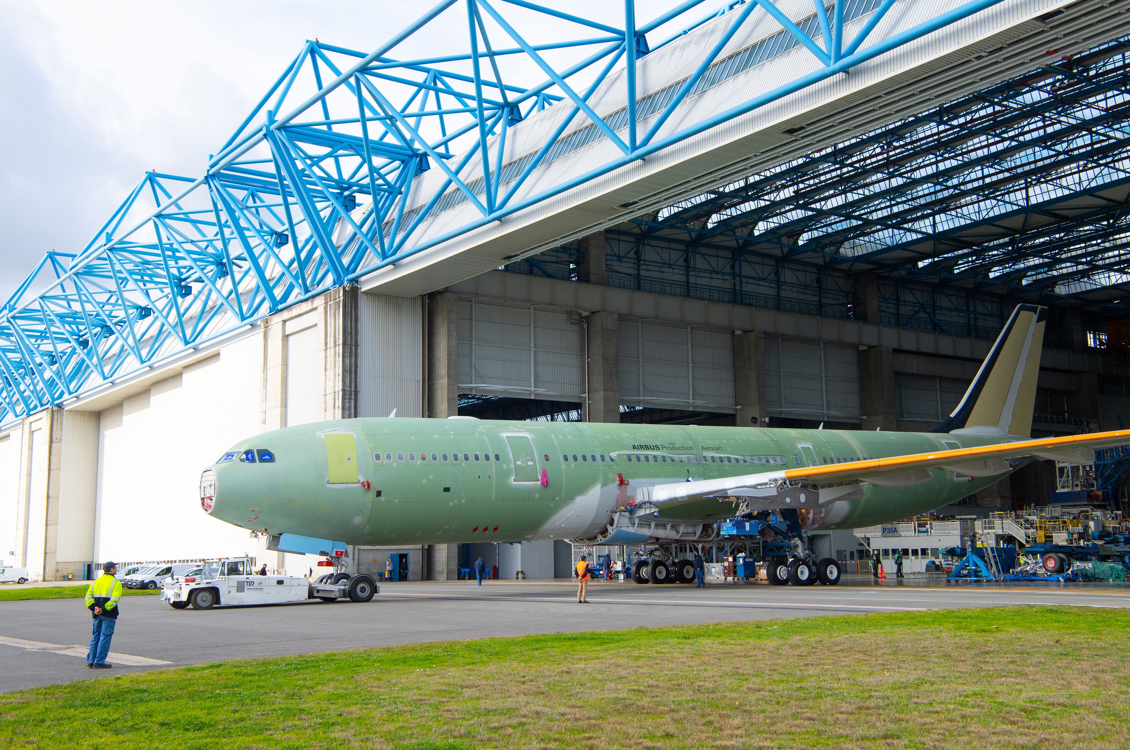 An Airbus A330 being transported out of a production facility.