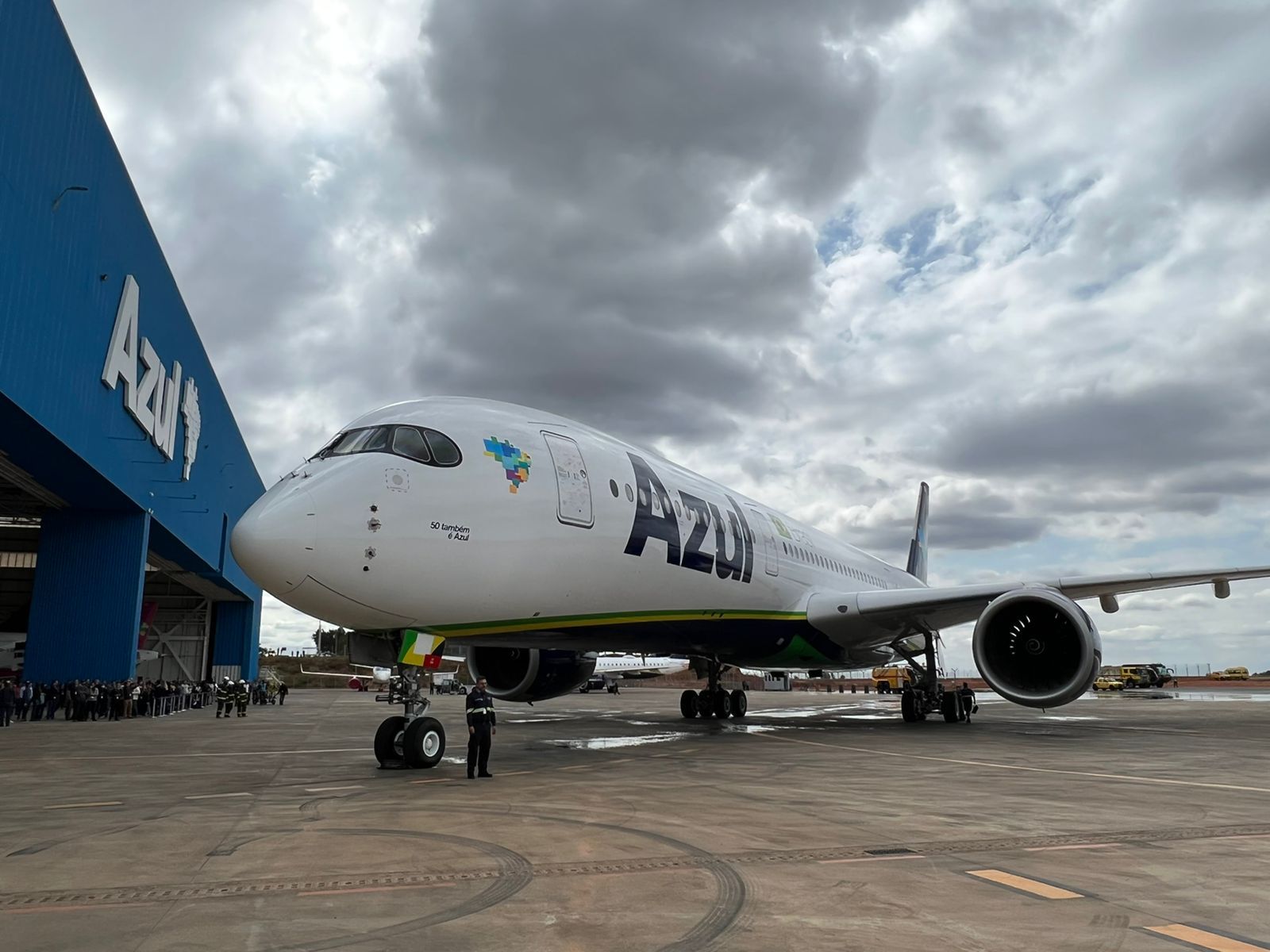 An Azul Airbus A350 aircraft parked outside of a hangar.