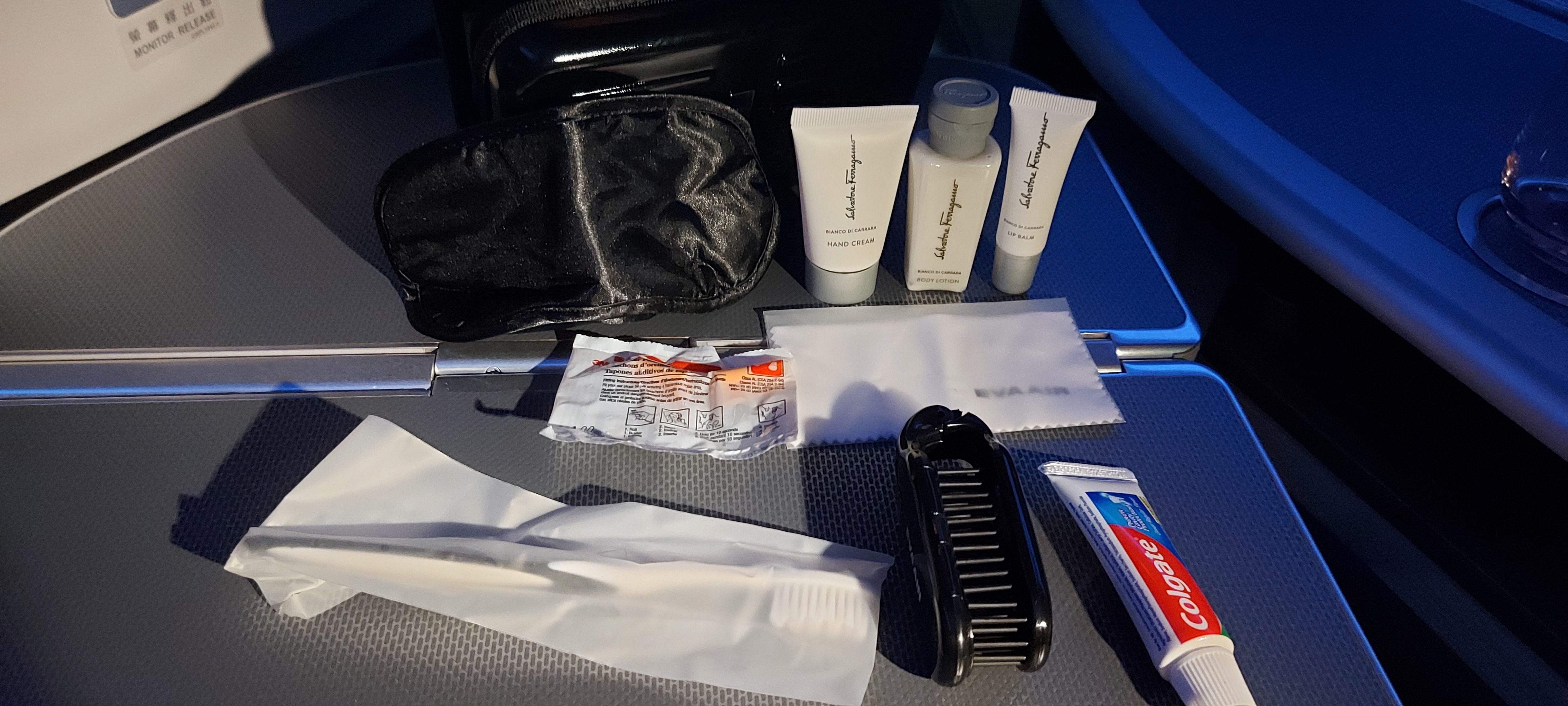 An EVA Air Business Class Amenity Kit with contents on the tray table.