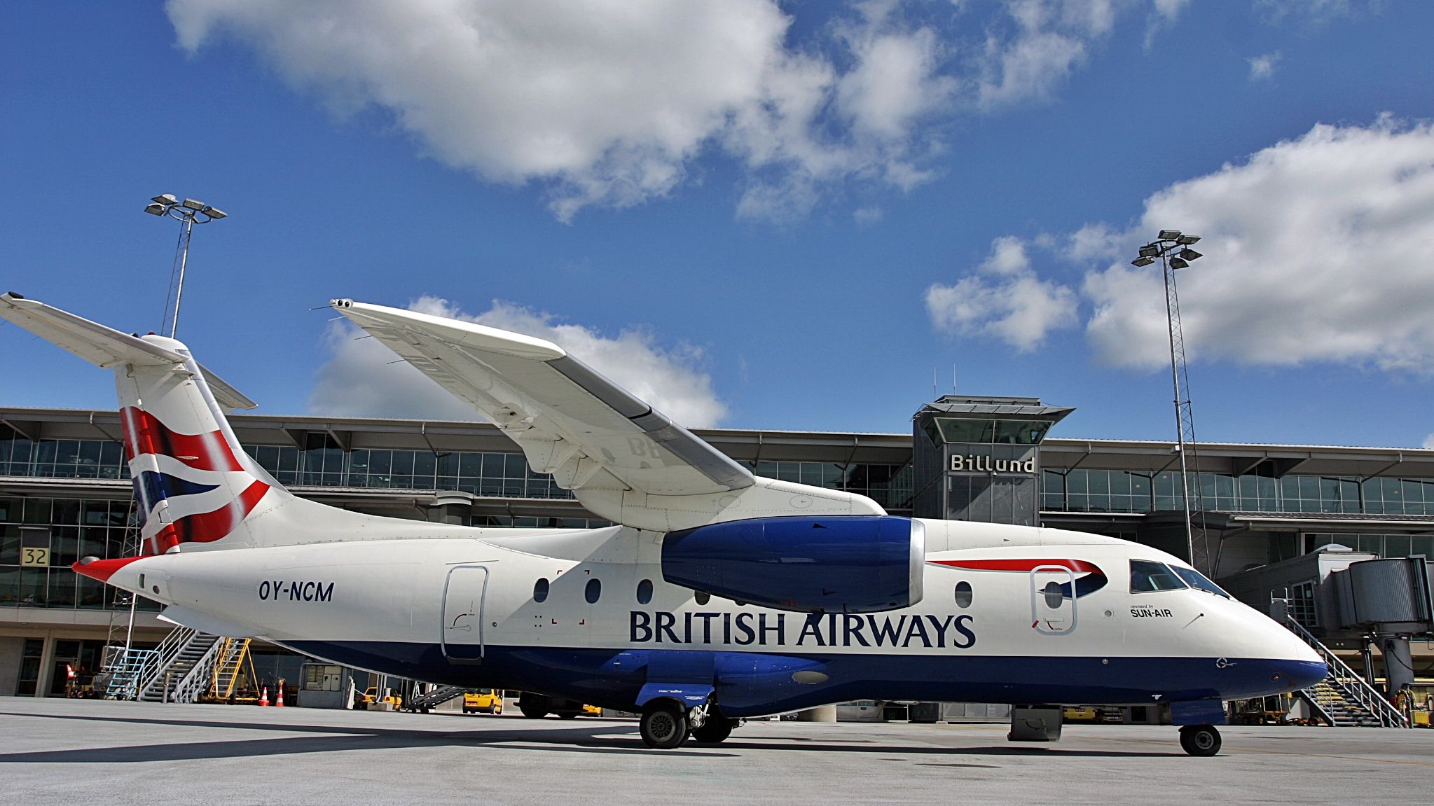 A SUN-AIR Dornier 328 in British Airways colors parked at an airport.