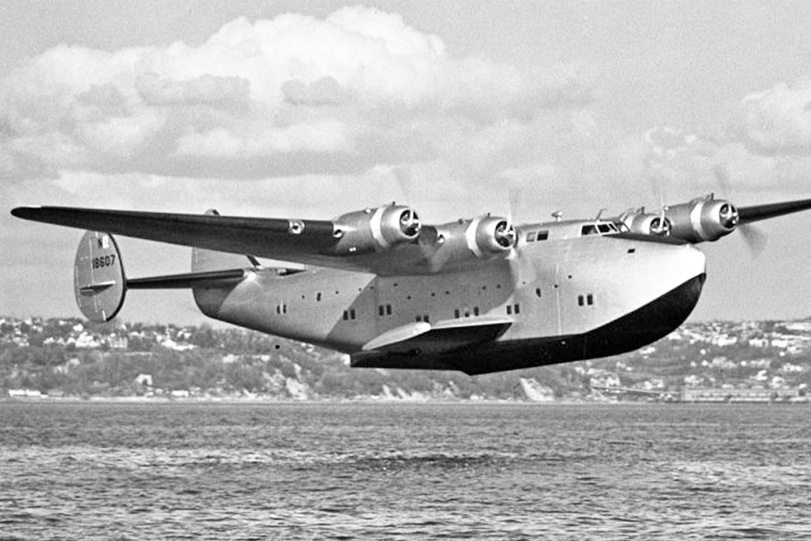 A Boeing 314 flying just above water.