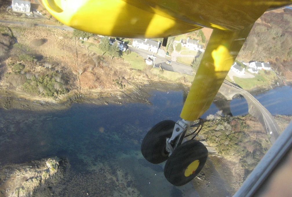 AHebridean Air Services aircraft flying over a residential area.