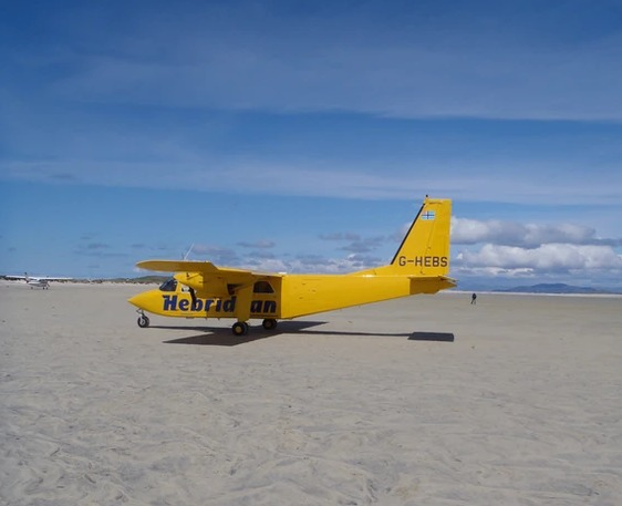 A Hebridean Air Services Islander parked on sand.