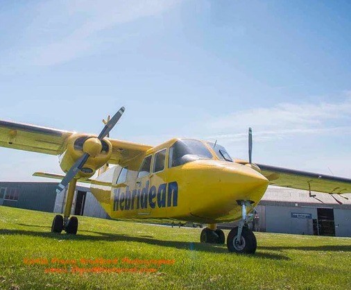 A Hebridean Air Services aircraft parked on grass.