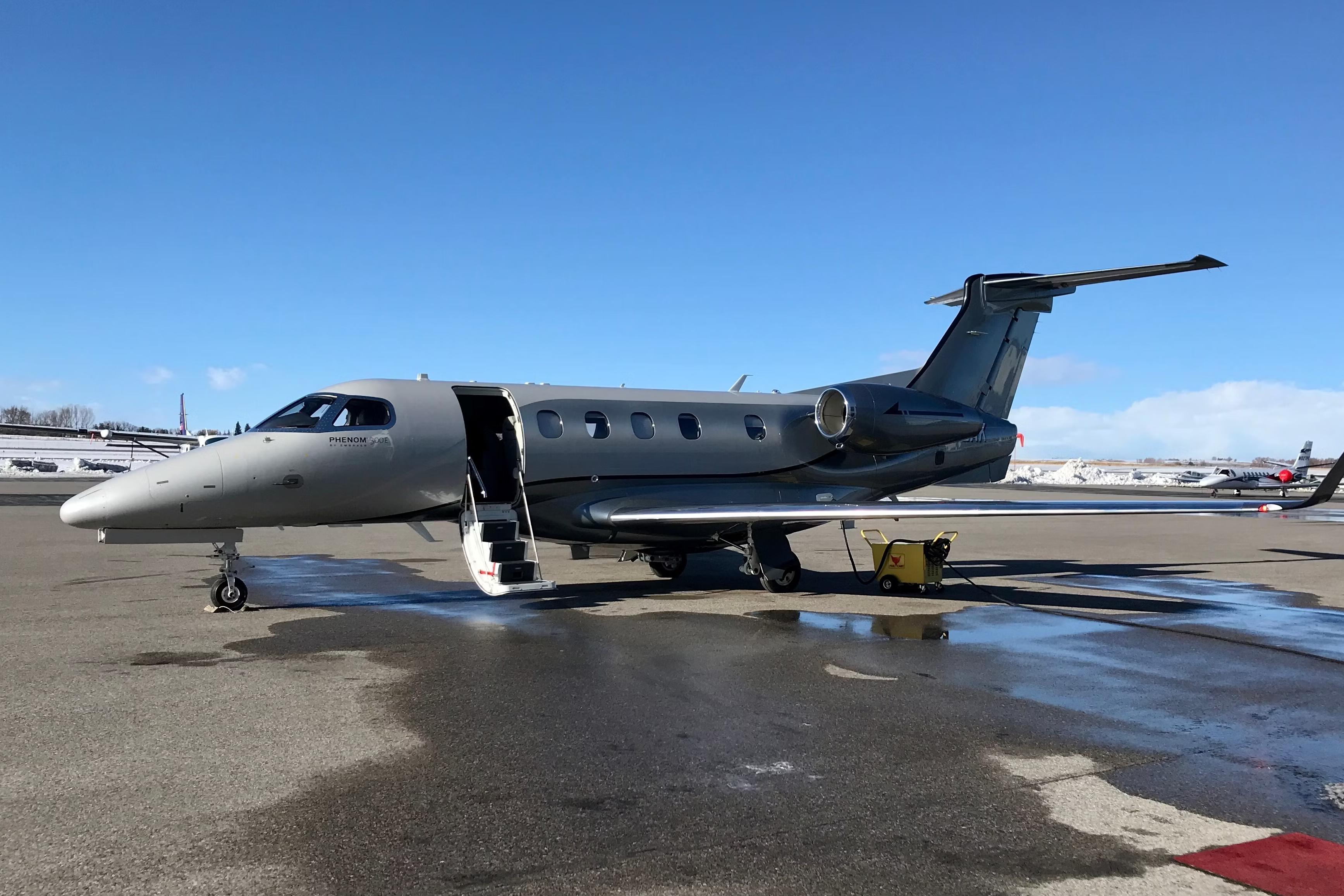 An Embraer Phenom 300 parked at an airport.