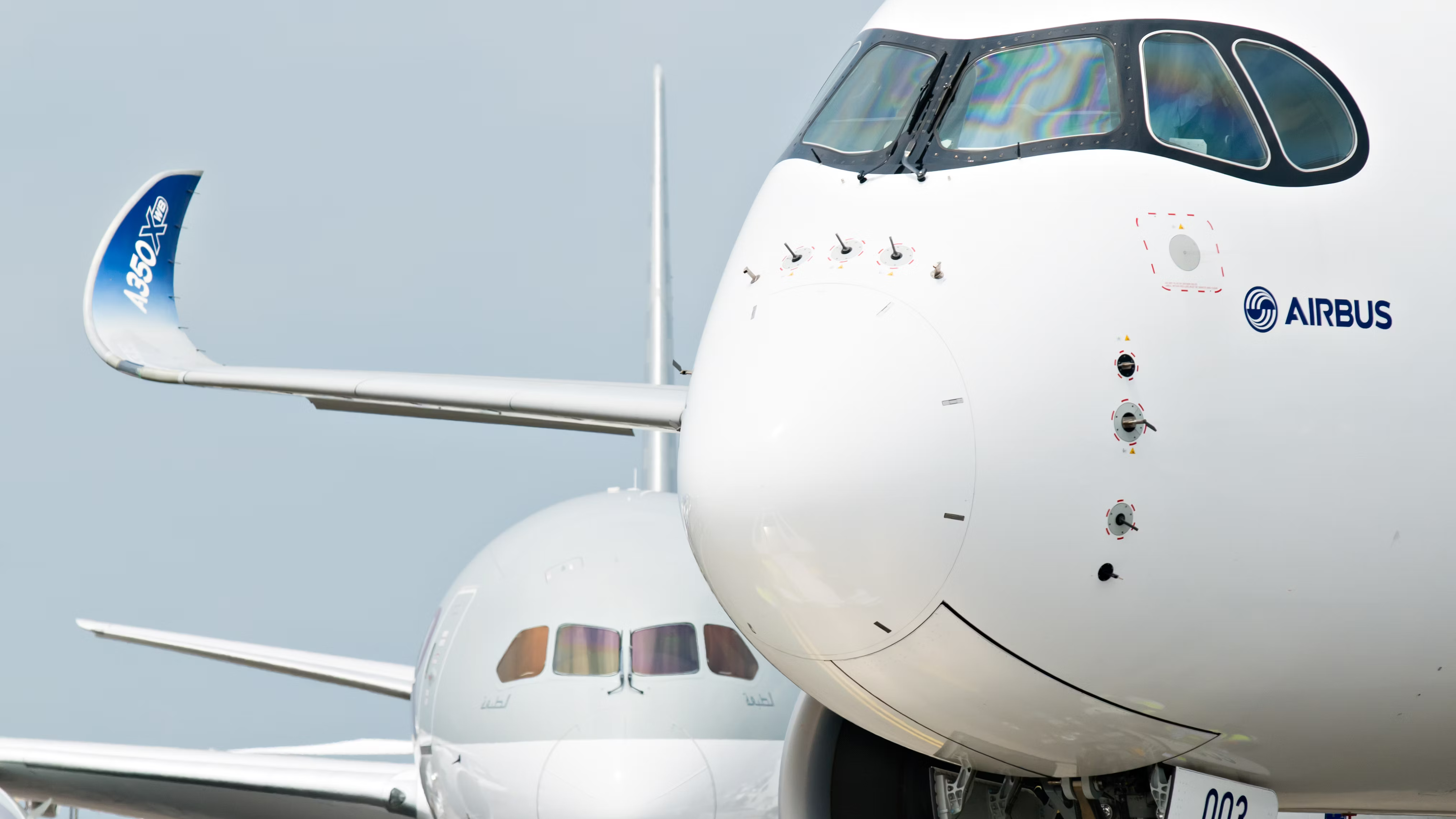 A closeup of an Airbus A350 XWB aircraft with a Boeing 787 Dreamliner in the background.