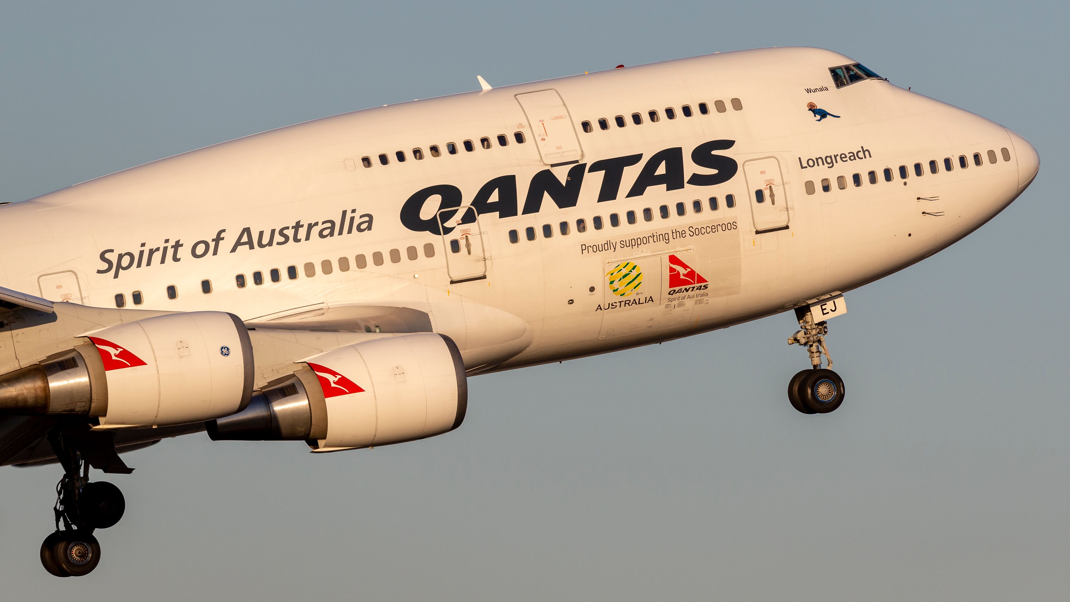 A closeup of a Qantas Boeing 747 flying in the sky.