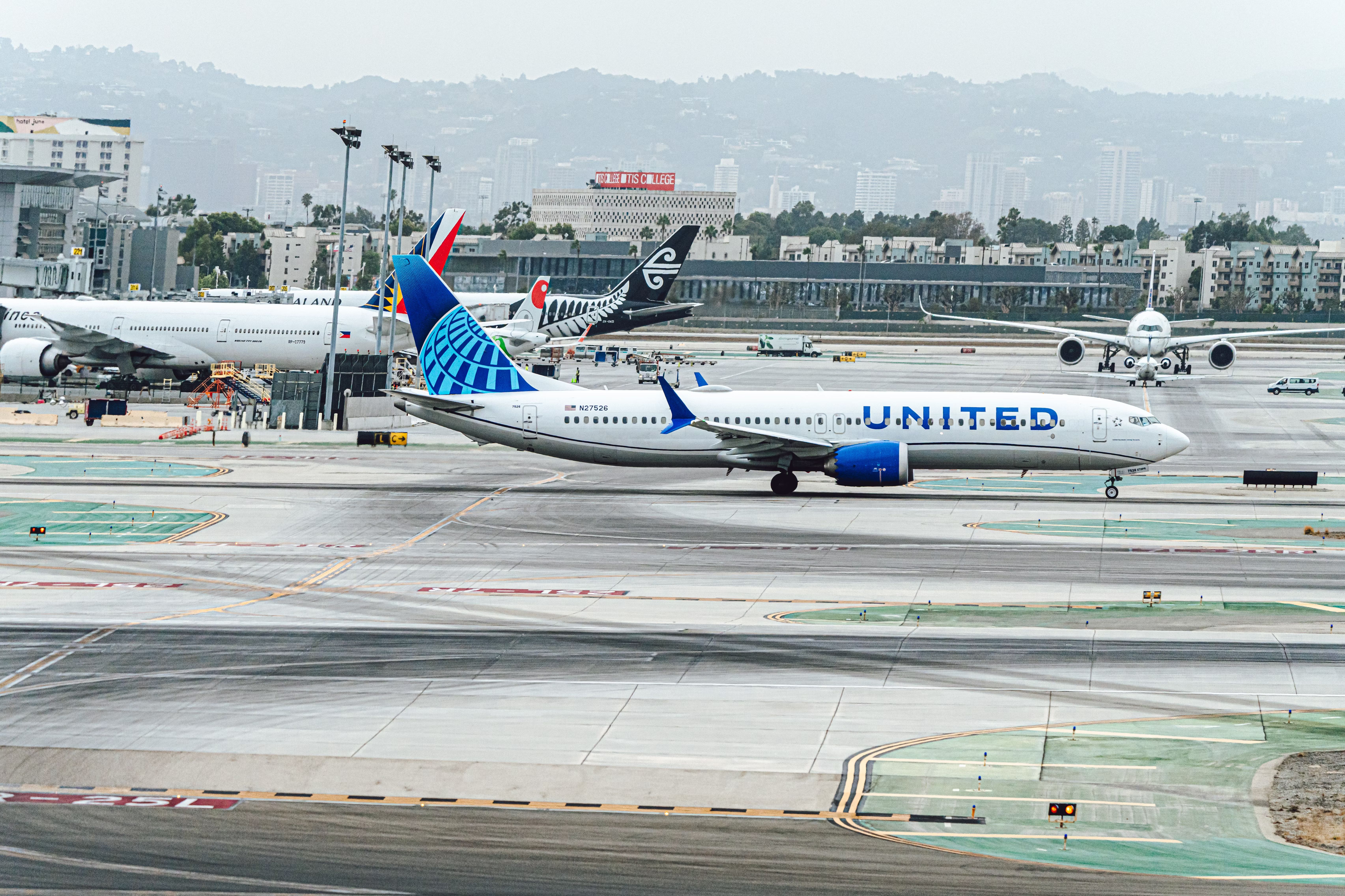 A United Airlines Boeing 737 MAX 9 on an airport apron near Philippine Airlines and Air New Zealand Aircraft.