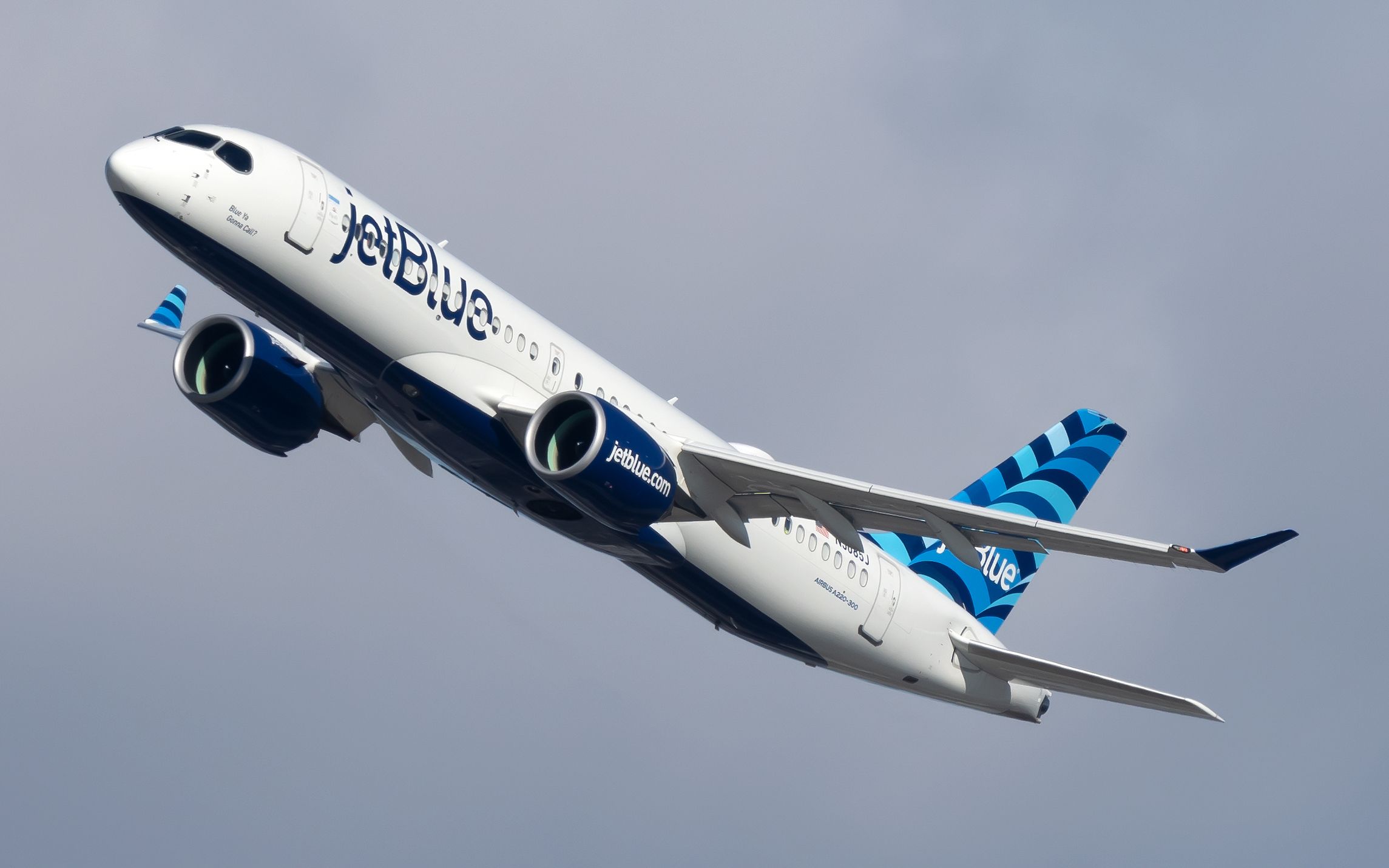 A JetBlue Airways Airbus A220-300 flying in the sky.