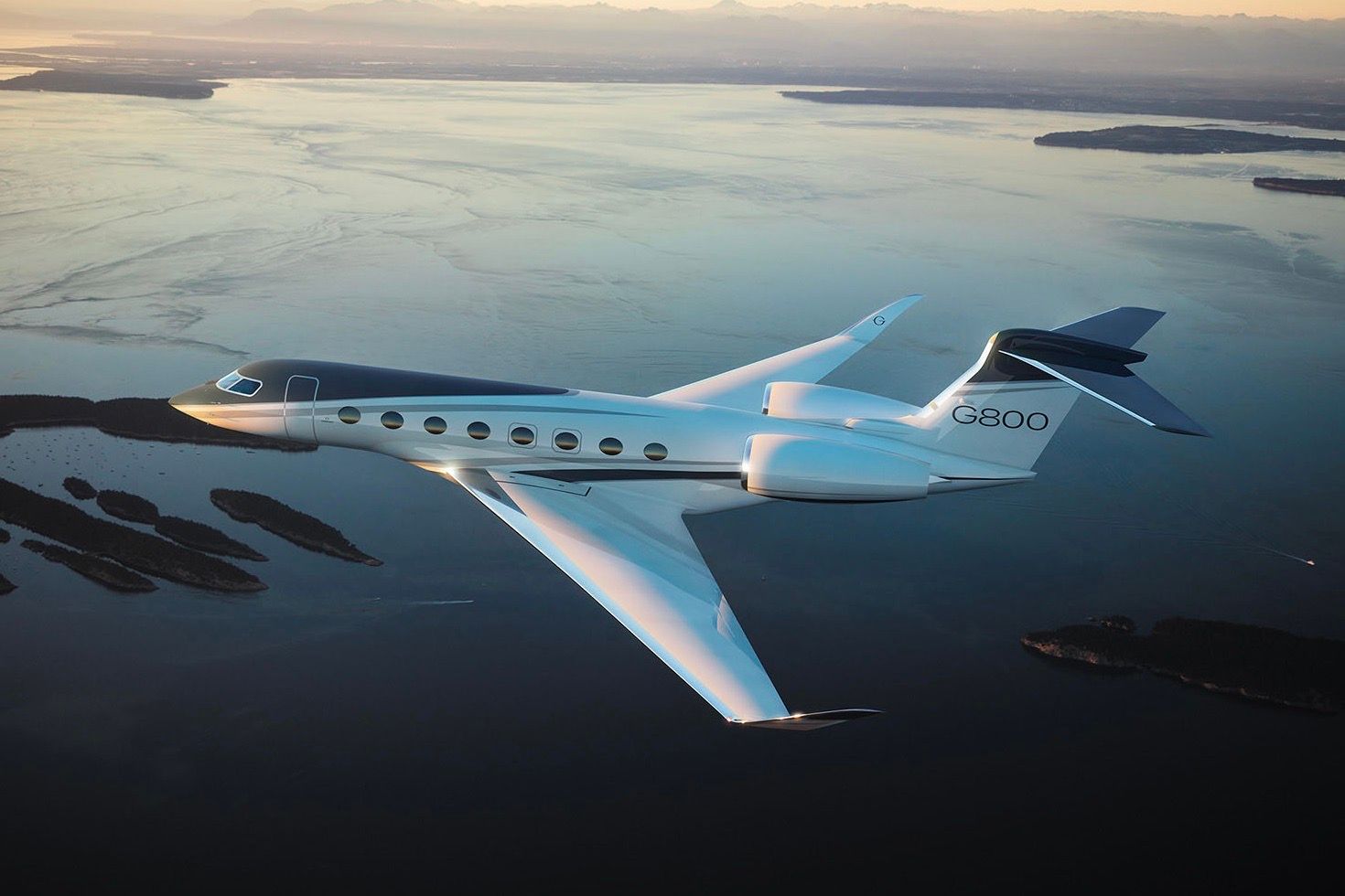 A Gulfstream G800 flying over water.