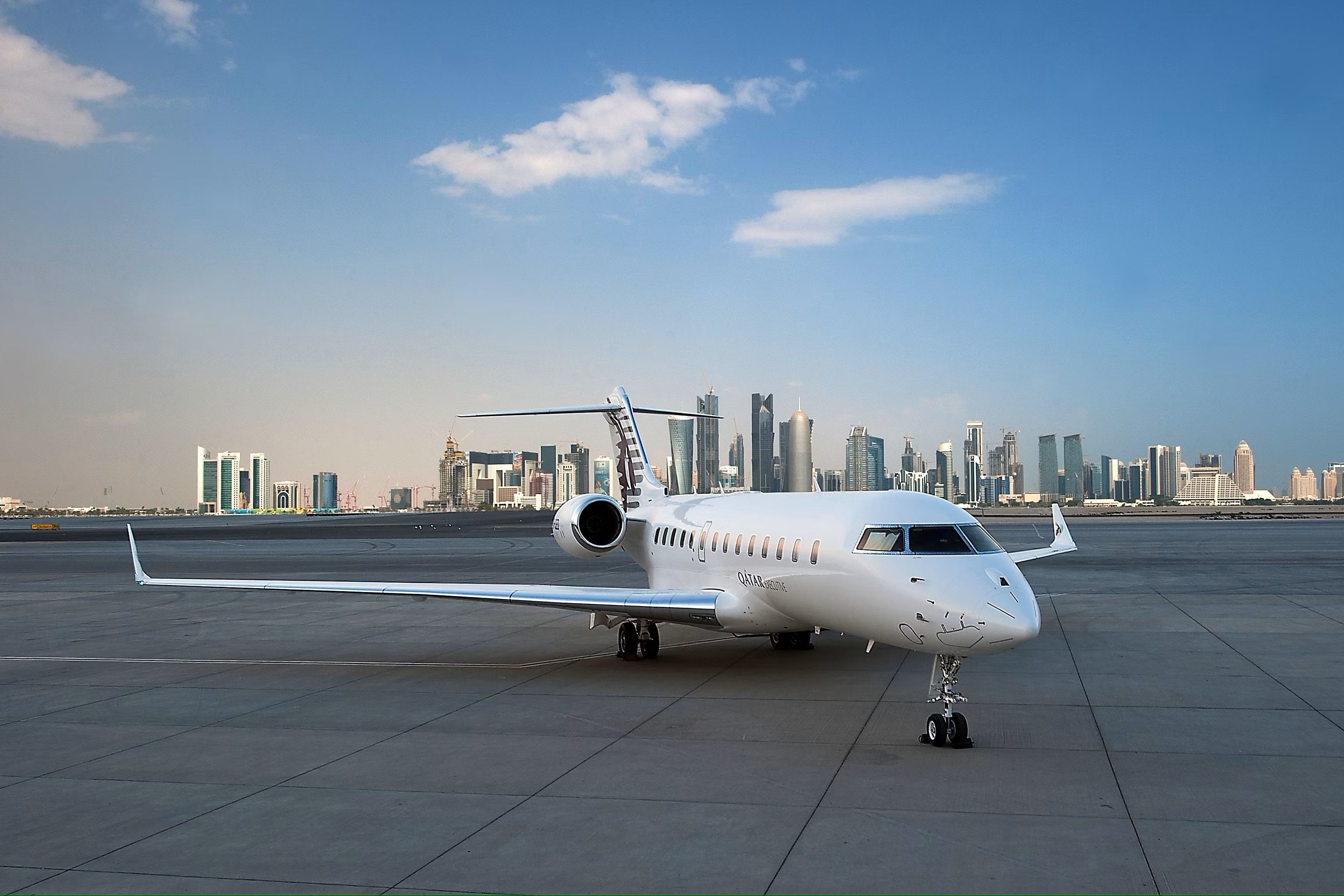 A Qatar Executive Bombardier Global 5000 Vision PC QAE parked at an airport.