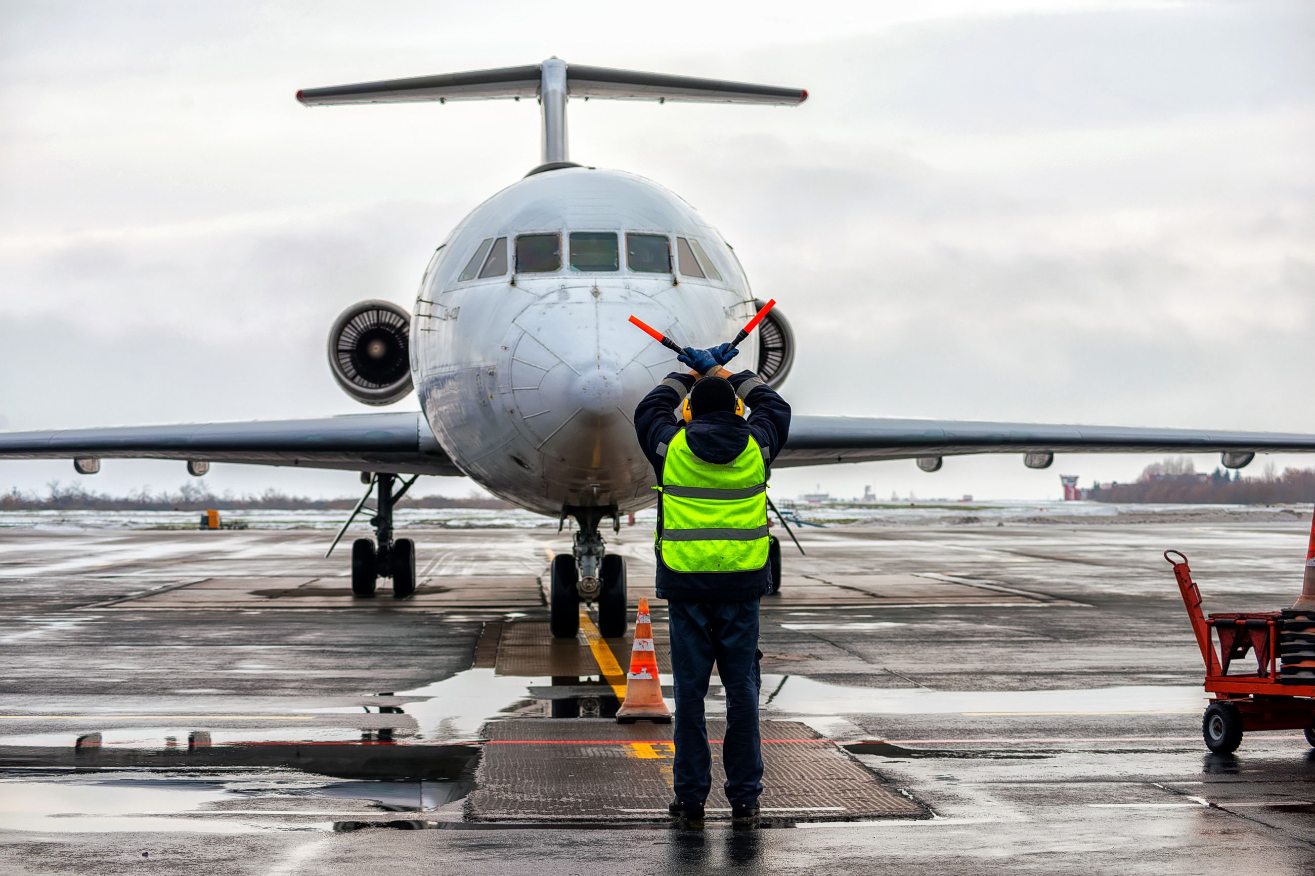 An Aircraft Marshal using hand signals to tell a pilot to stop moving.