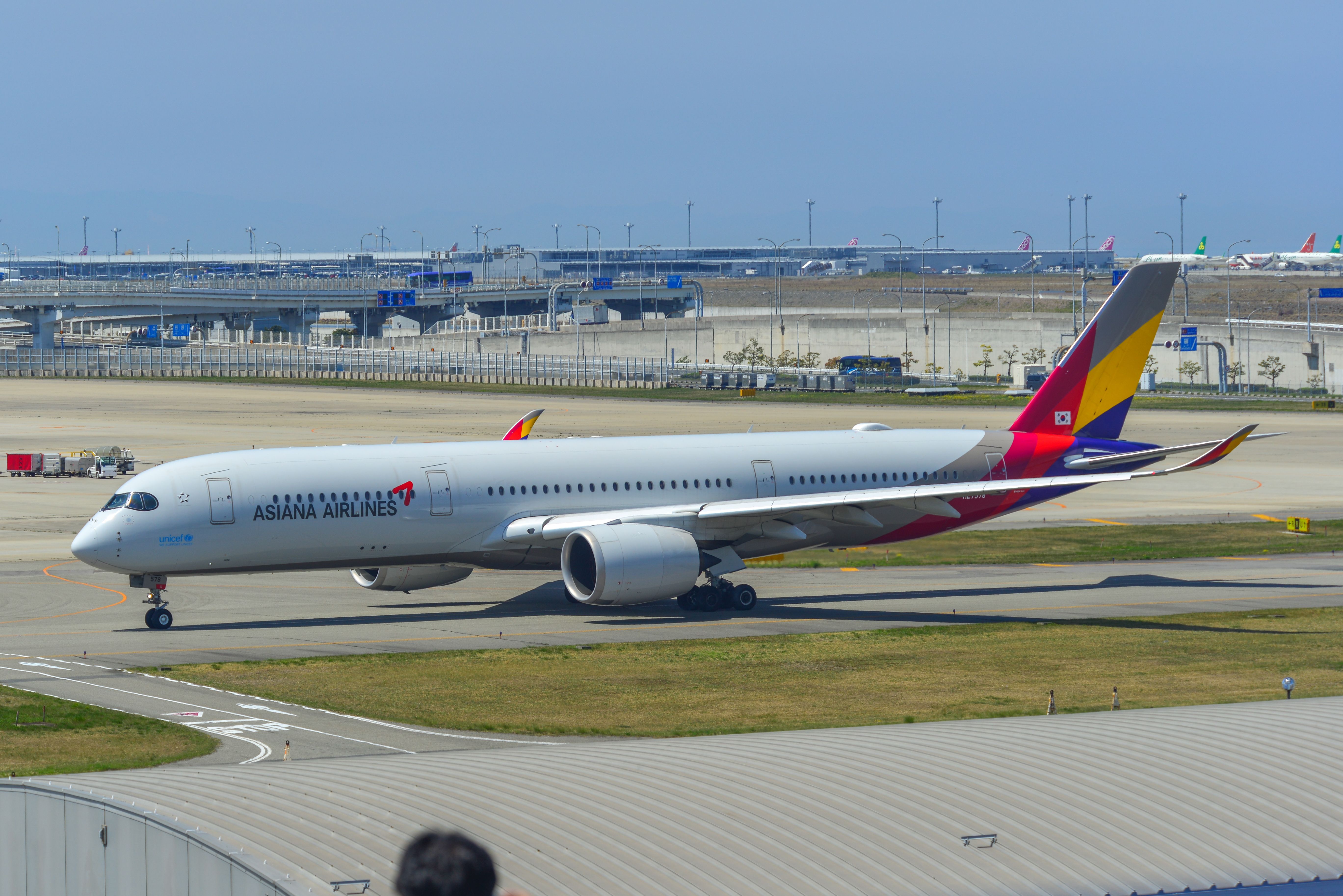 Asiana Airlines Airbus A350-900 taxiing on runway of Kansai Airport.