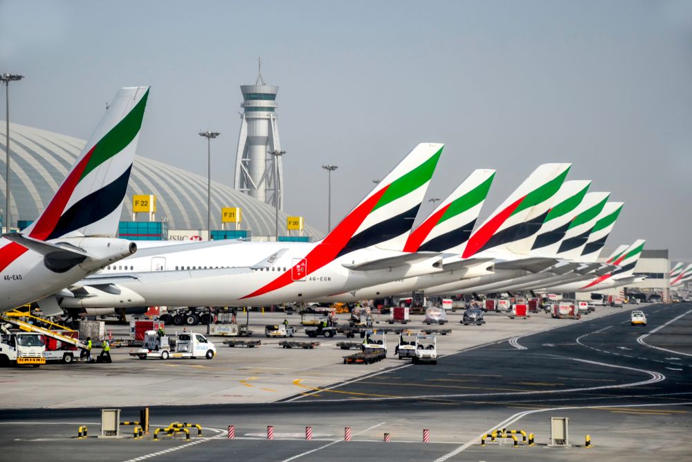 Several Emirates widebody aircraft parked at Dubai International Airport.
