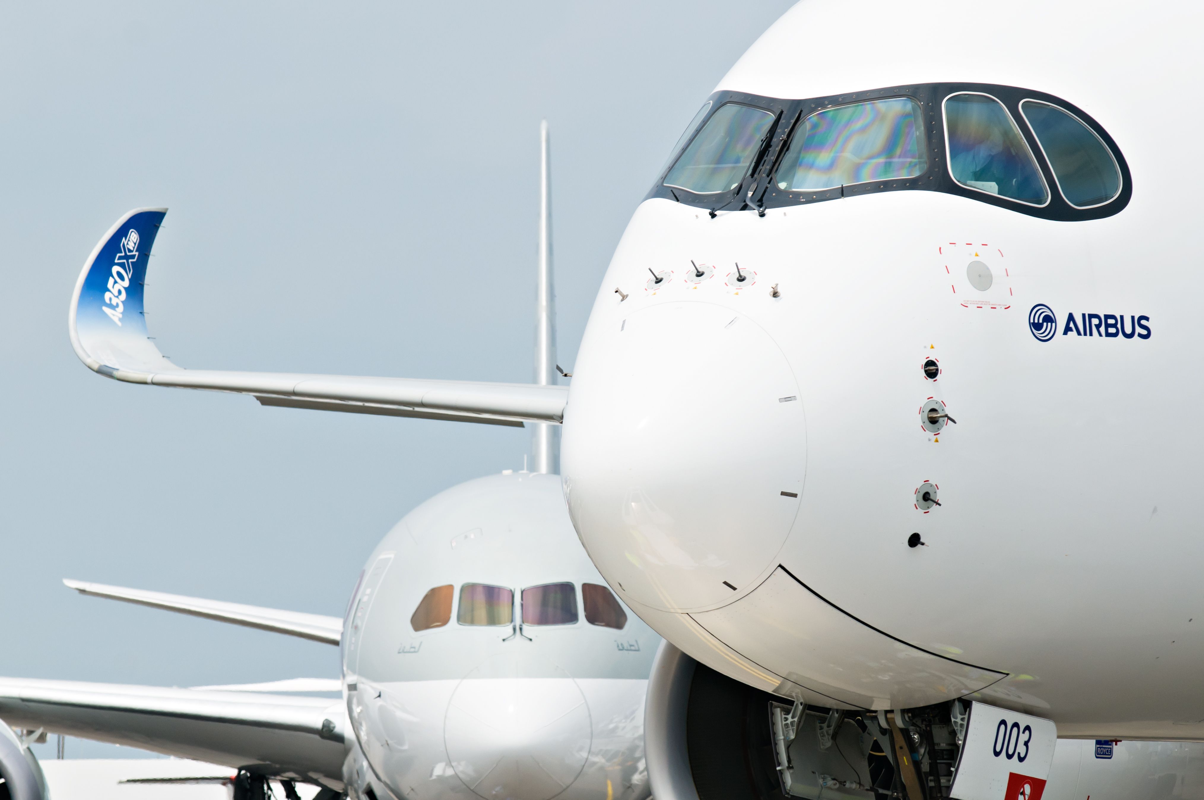 A closeup of an Airbus A350 XWB aircraft with a Boeing 787 Dreamliner in the background.