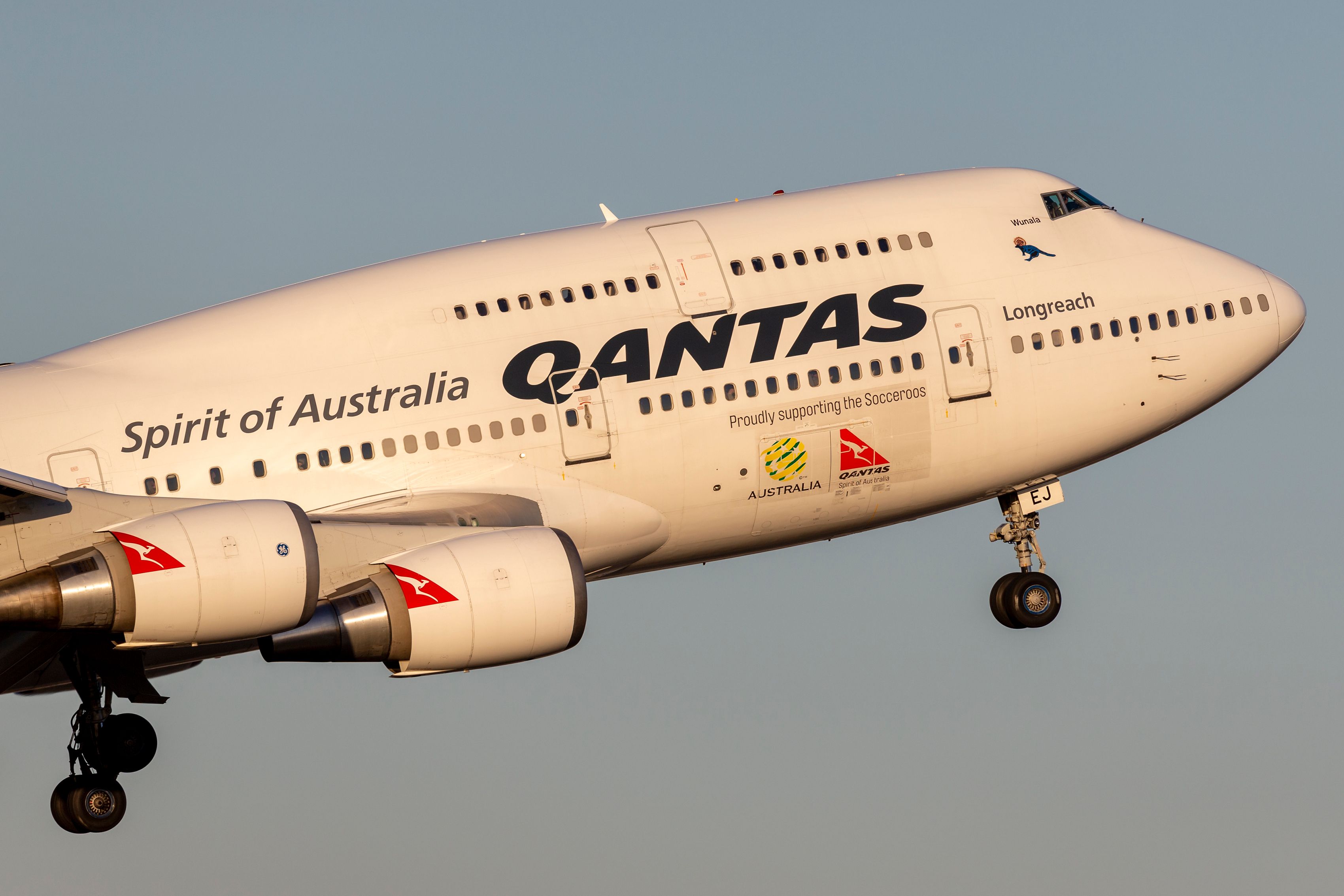A closeup of a Qantas Boeing 747 flying in the sky.