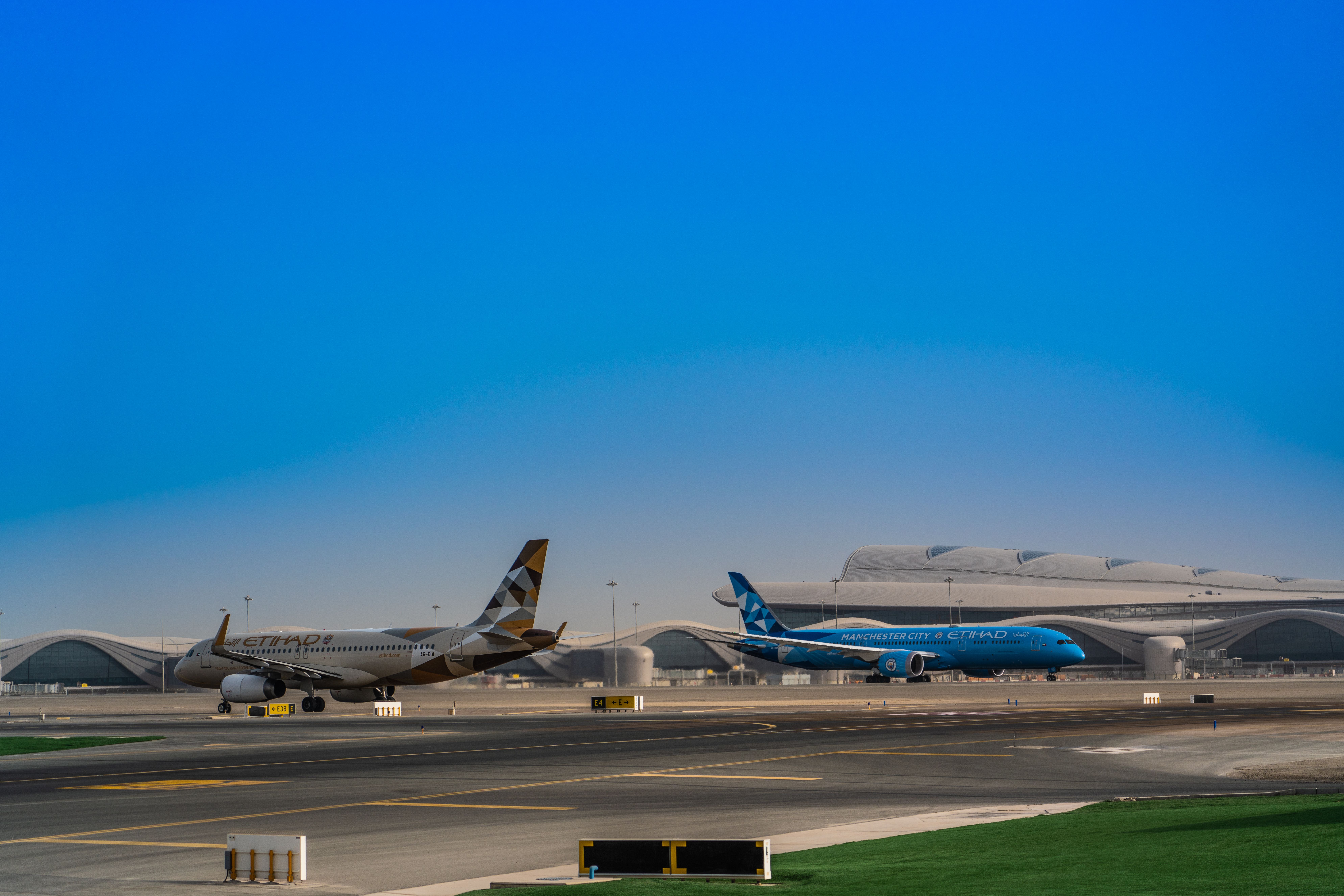 Etihad Airbus A320 and 787 Dreamliner in special livery at Abu Dhabi International Airport.