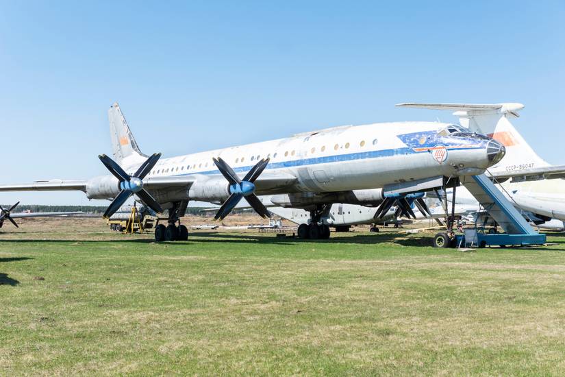 A retired Tupolev Tu-114 sitting in a field.