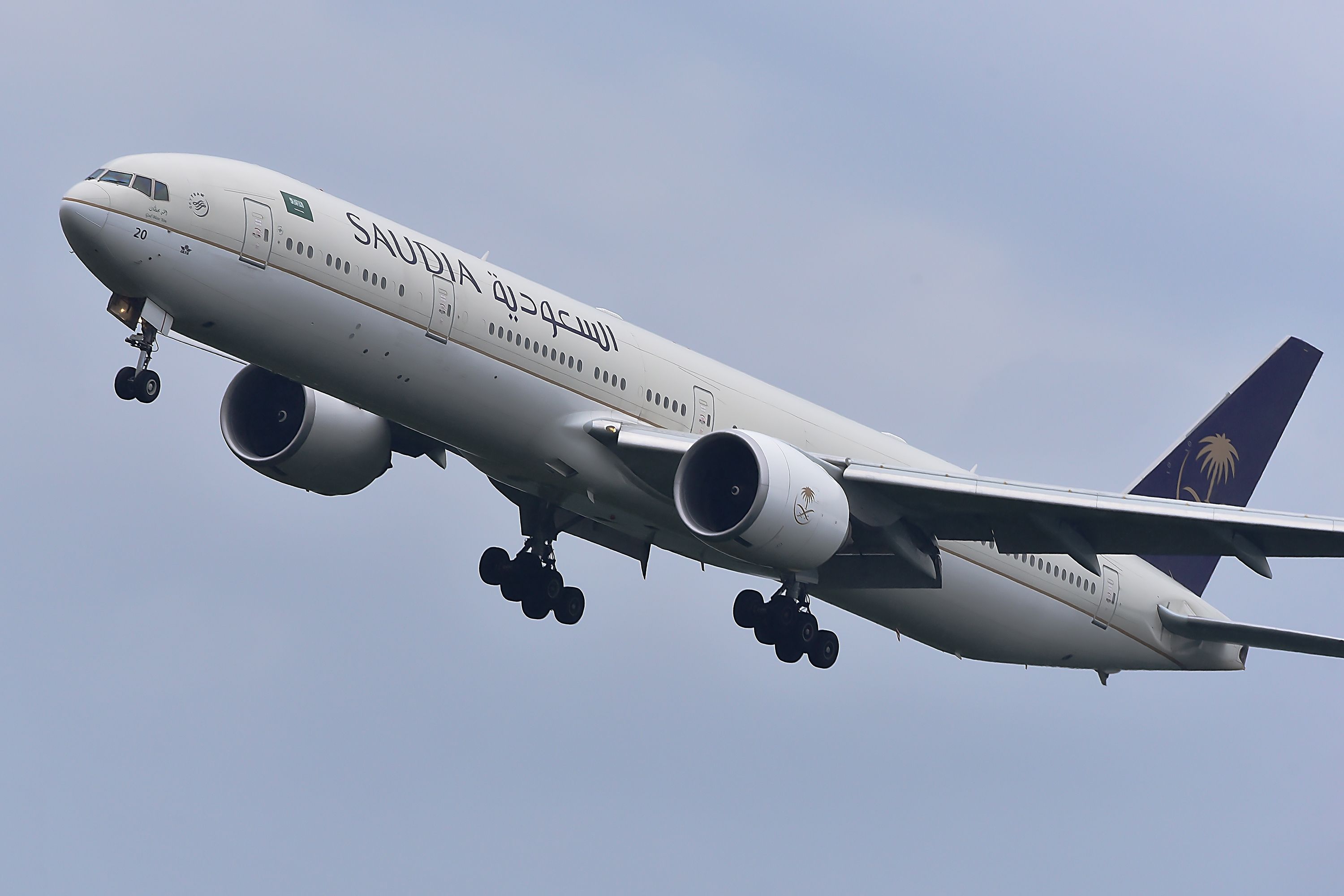 Saudia Boeing 777 over airport.