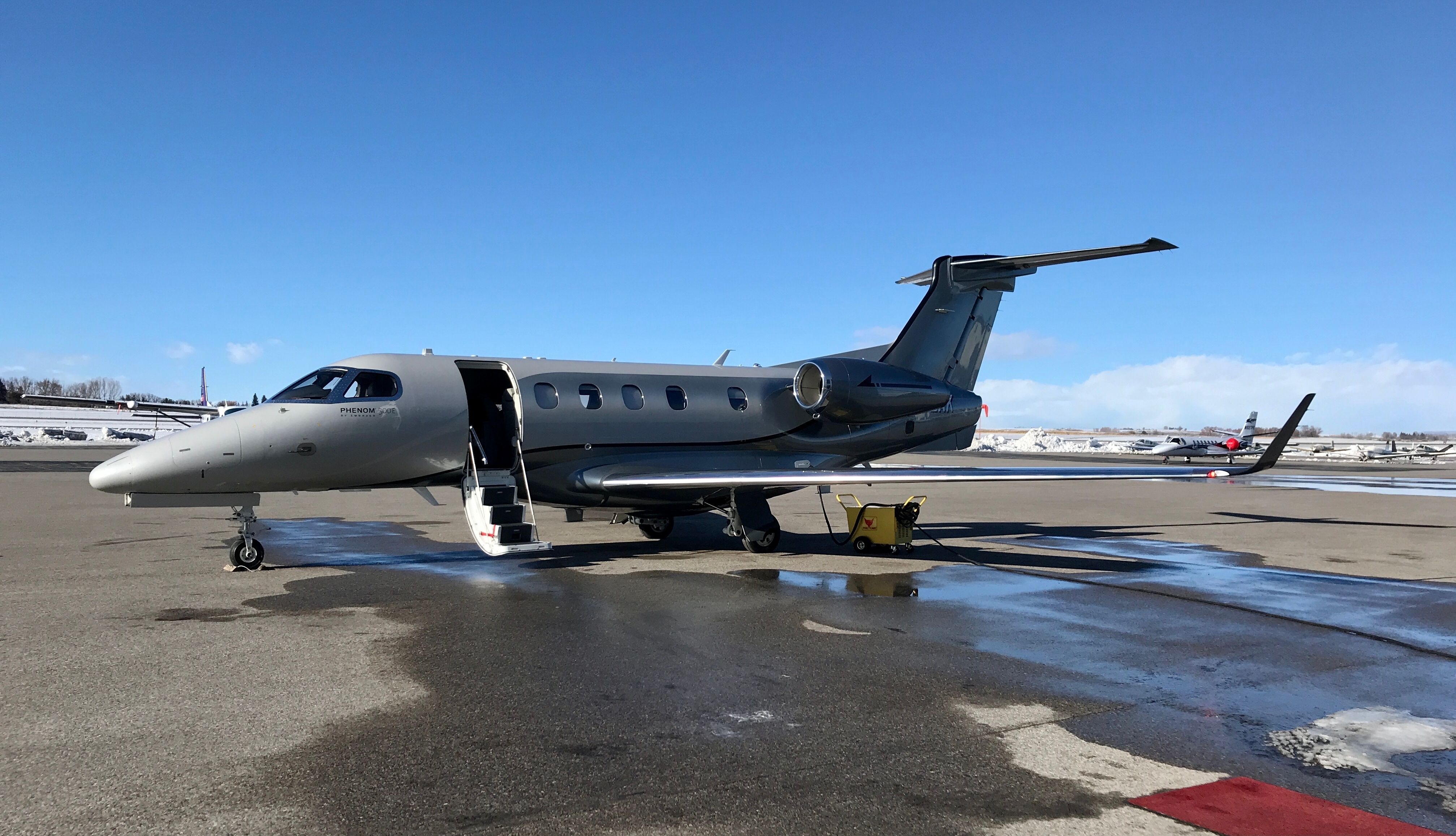 An Embraer Phenom 300 private jet parked at an airport